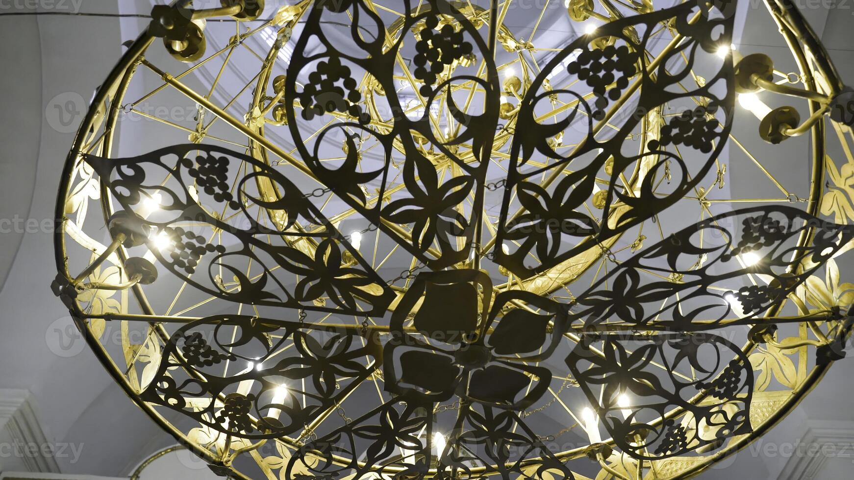 Beautiful gilded chandelier in Church. Stock footage. Panikadilo is main lamp of temple and symbol of Heavenly Church. Openwork patterns Church chandeliers with candles look divine photo