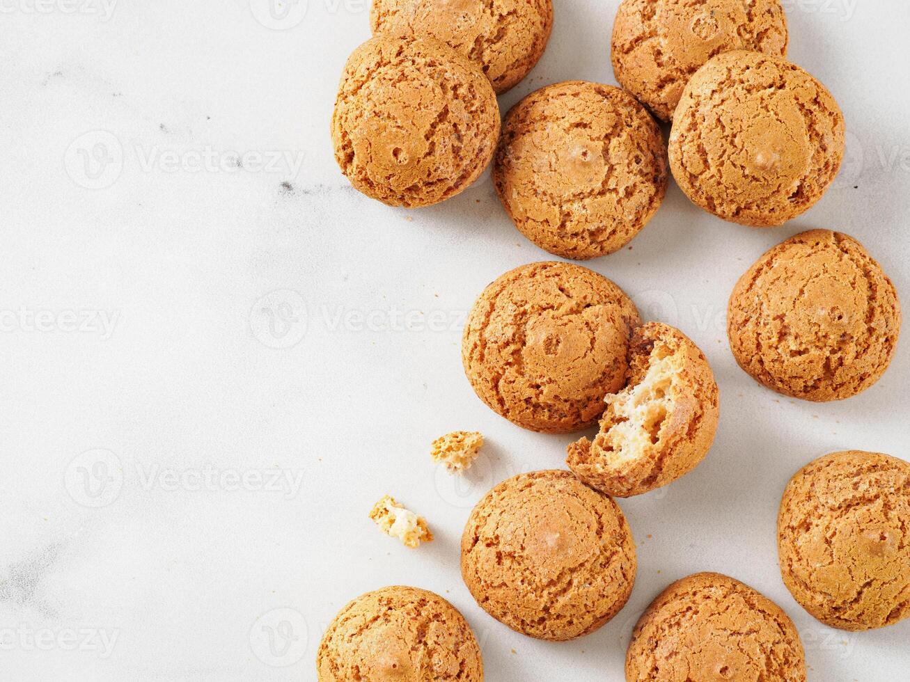 pile of cookie amaretti on white marble background - traditional Italian Sardinian pastry. Delicious amaretti biscuit cookies made from almond or apricot kernels with copy space photo