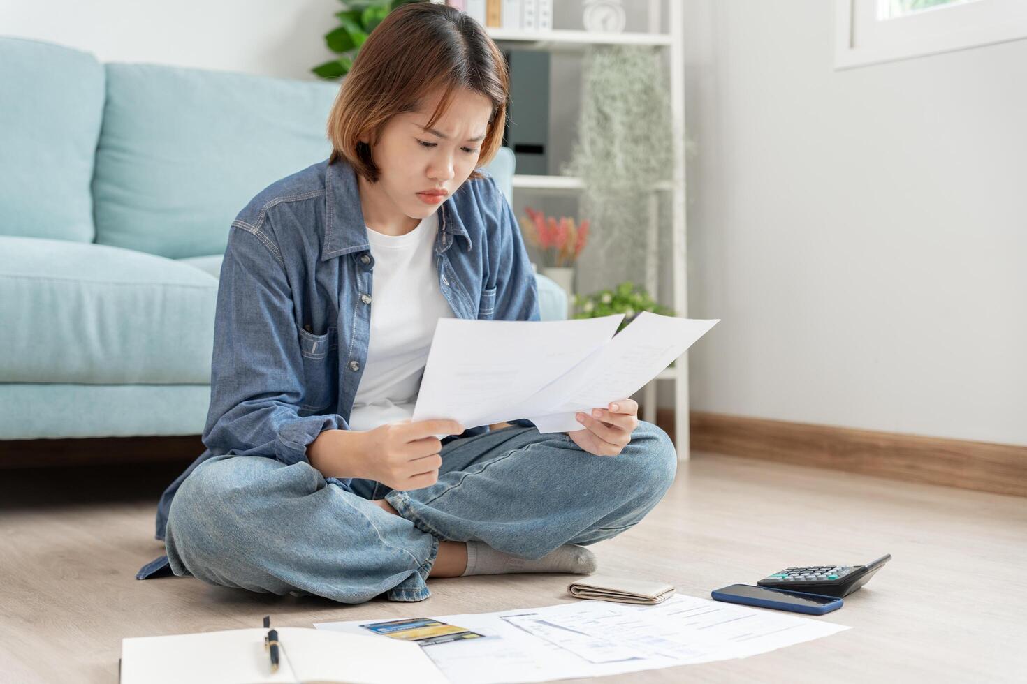 Stressed and headache asian woman with large bills or invoices no money to pay to expenses and credit card debt. shortage, Financial problems, mortgage, loan, bankruptcy, bankrupt, poor, empty wallet photo
