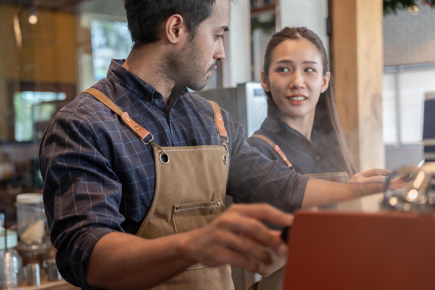 Asia couple owner happy and smile receive order from customer. guarantees safety, cleanliness, open the coffee shop. open for New normal. Small business, welcome, restaurant, home made, cafe photo