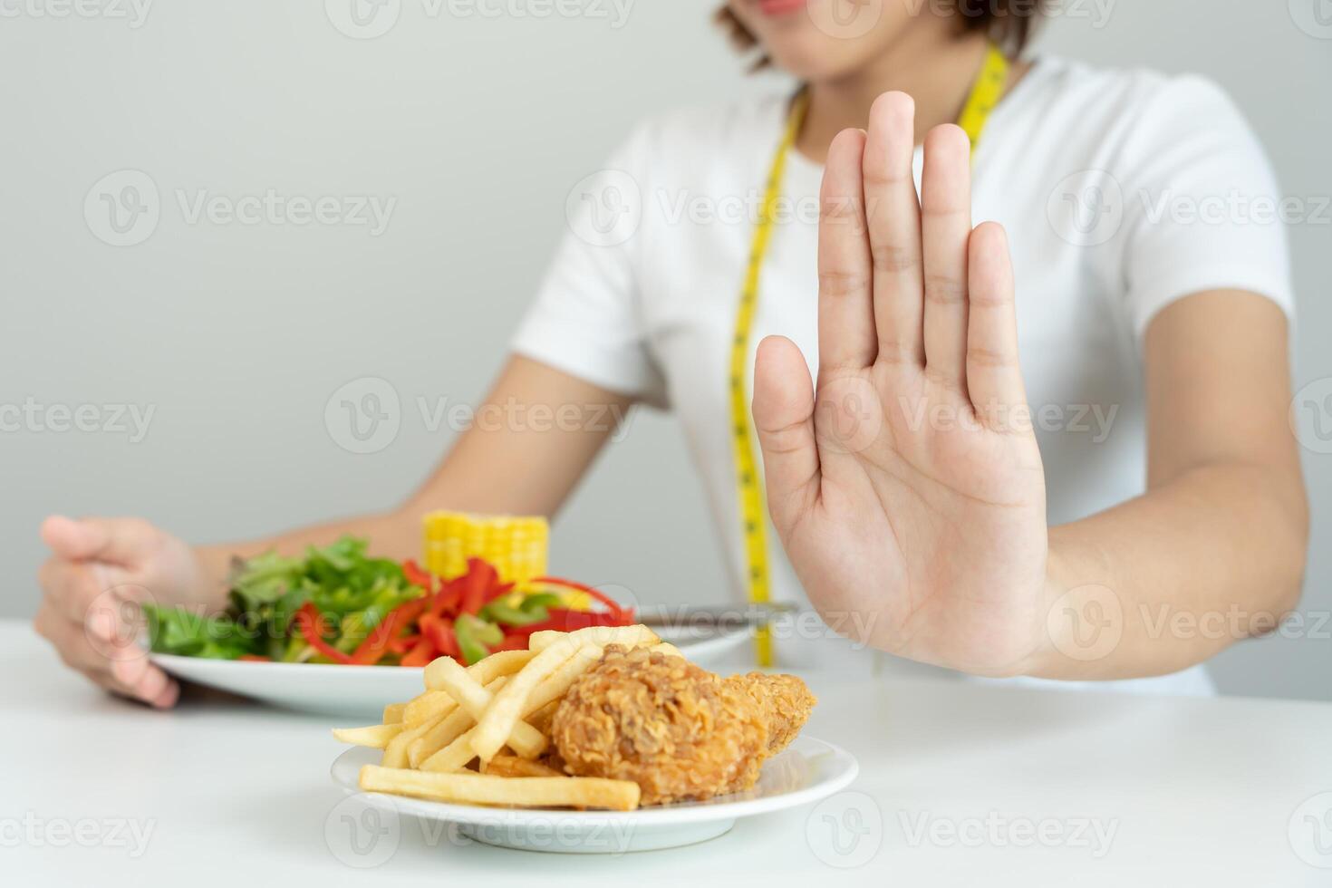 Beauty slim female body confuse French fries and fried chicken. Woman in restaurant achieves weight loss goal for healthy life, crazy about thinness, thin waist, nutritionist. Diet, body shape. photo