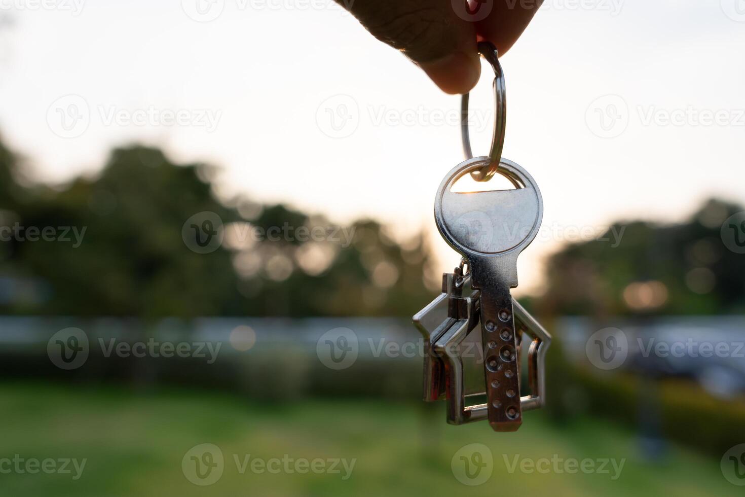 Landlord key for unlocking house is plugged into the door. Second hand house for rent and sale. keychain is blowing in the wind. mortgage for new home, buy, sell, renovate, investment, owner, estate photo