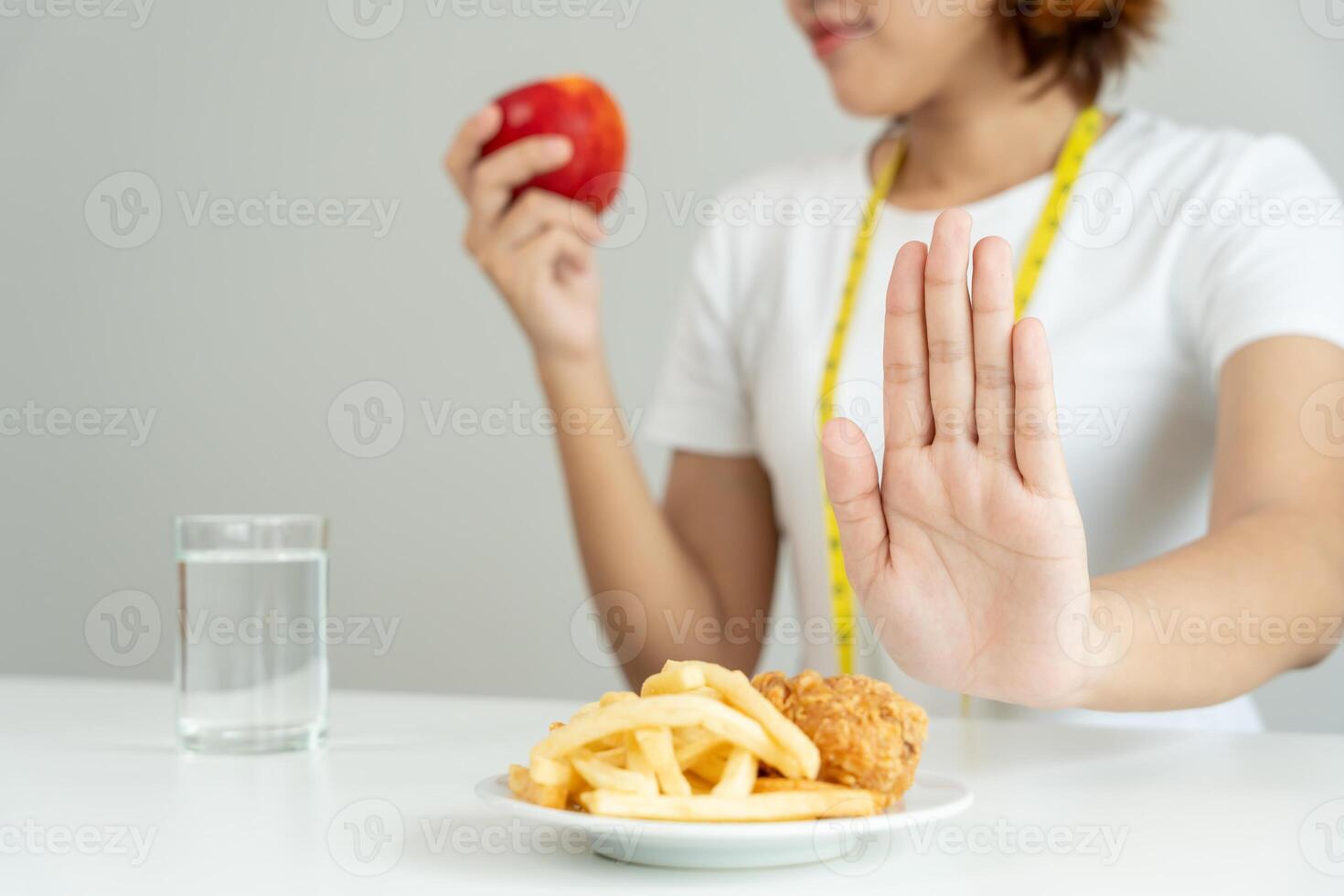 slim body Women refuse fast food or junk food, female choose apple for diet. Good healthy food. weight lose, balance, control, reduce fat, low calories, routines, exercise. rejection symbol photo
