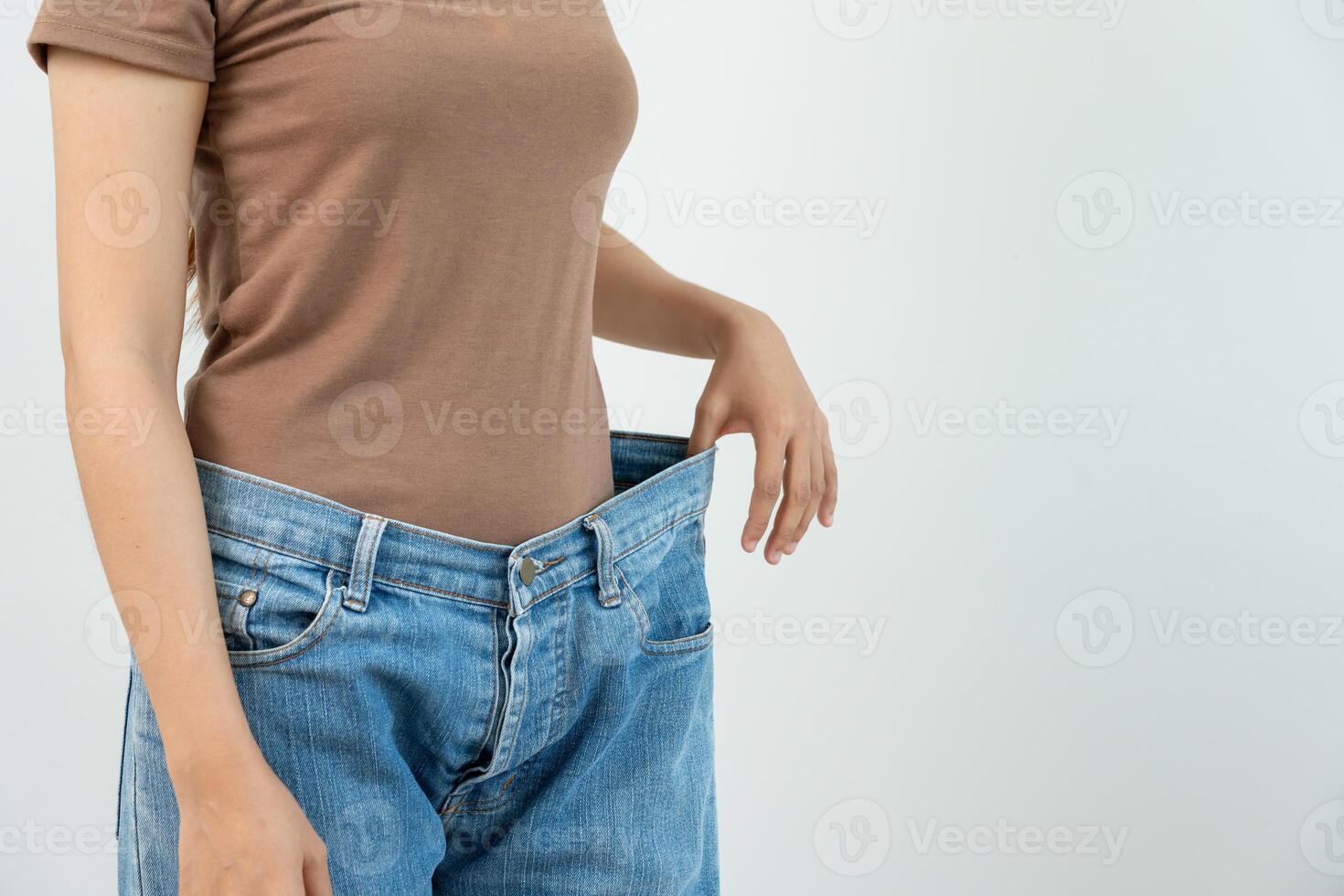 Women showing results of diet. Beautiful shape. female have a reduced waist size after under going a weight loss corse. can not wear jeans due to weight loss. balance, control, routines, exercise. photo