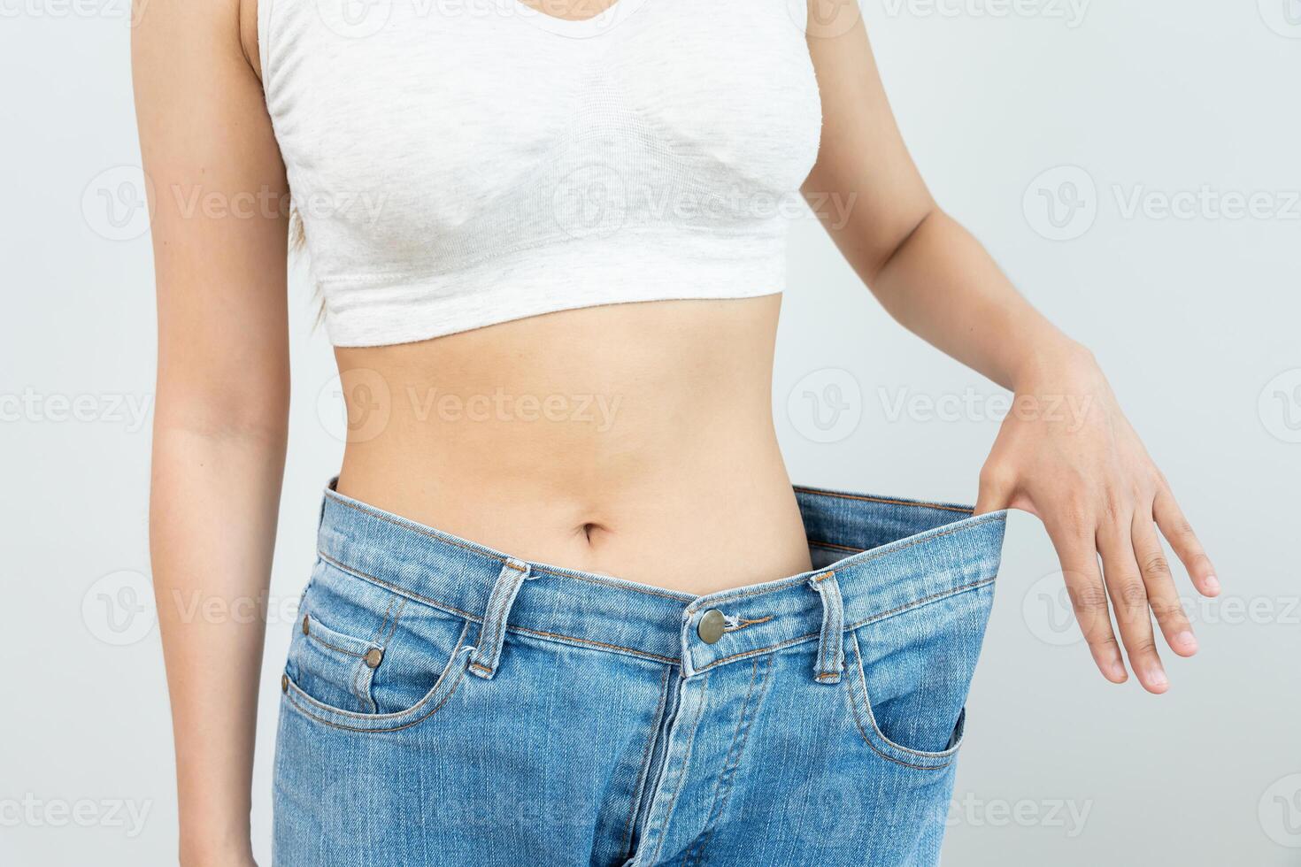 Women showing results of diet. Beautiful shape. female have a reduced waist size after under going a weight loss corse. can not wear jeans due to weight loss. balance, control, routines, exercise. photo