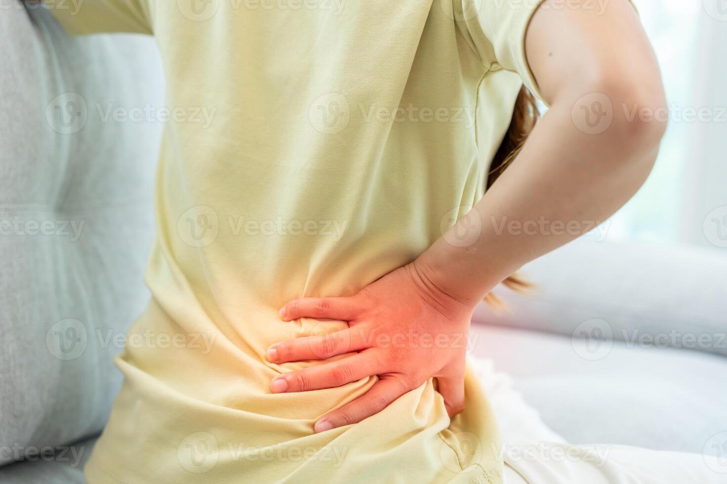 woman holding her lower back while and suffer from unbearable pain health and problems, chronic back pain, backache in office syndrome, scoliosis, herniated disc, muscle inflammation photo