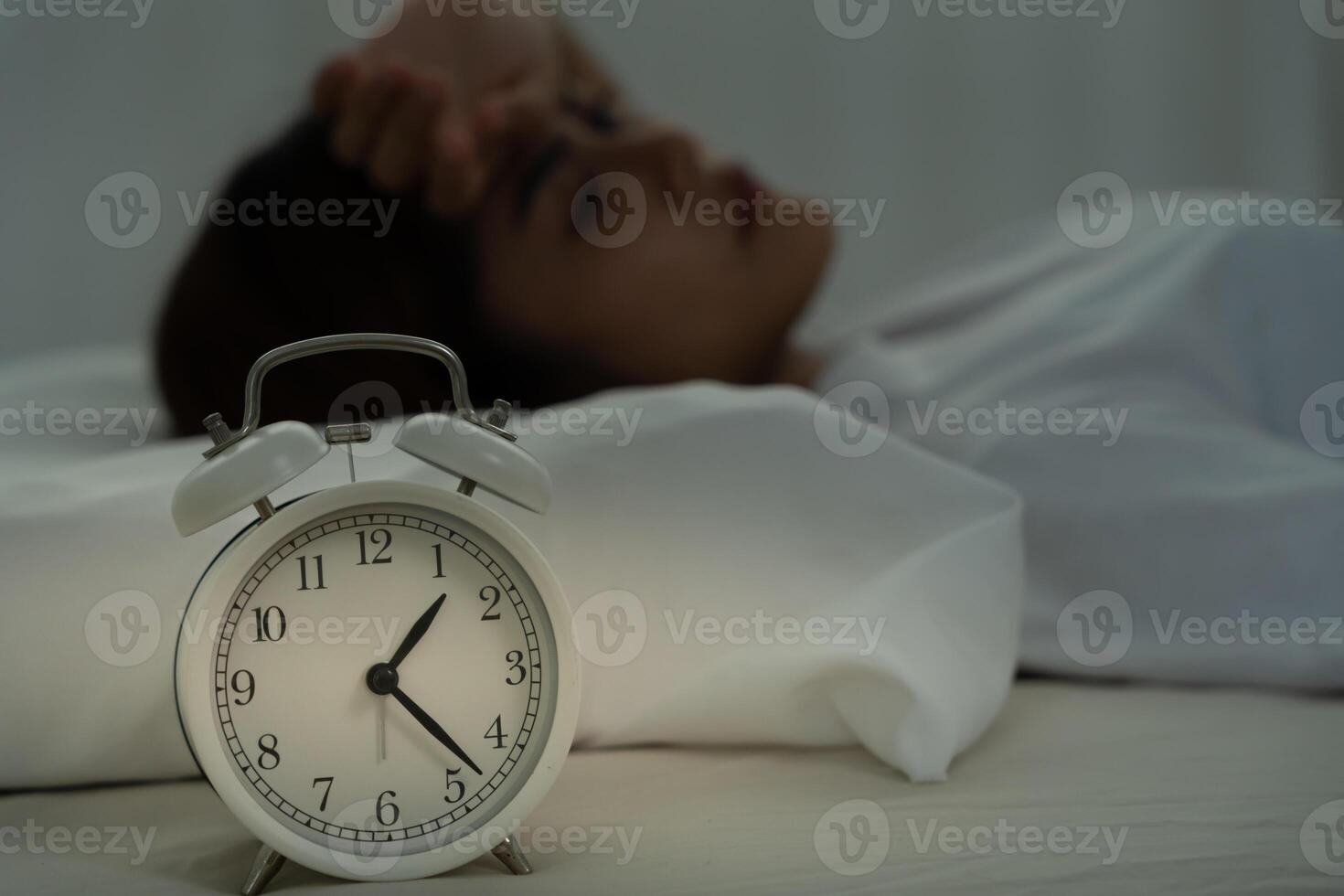 woman in bed late trying to sleep suffering insomnia, sleepless or scared in a nightmare, looking sad worried and stressed. Tired and headache or migraine waking up in the middle of the night. photo
