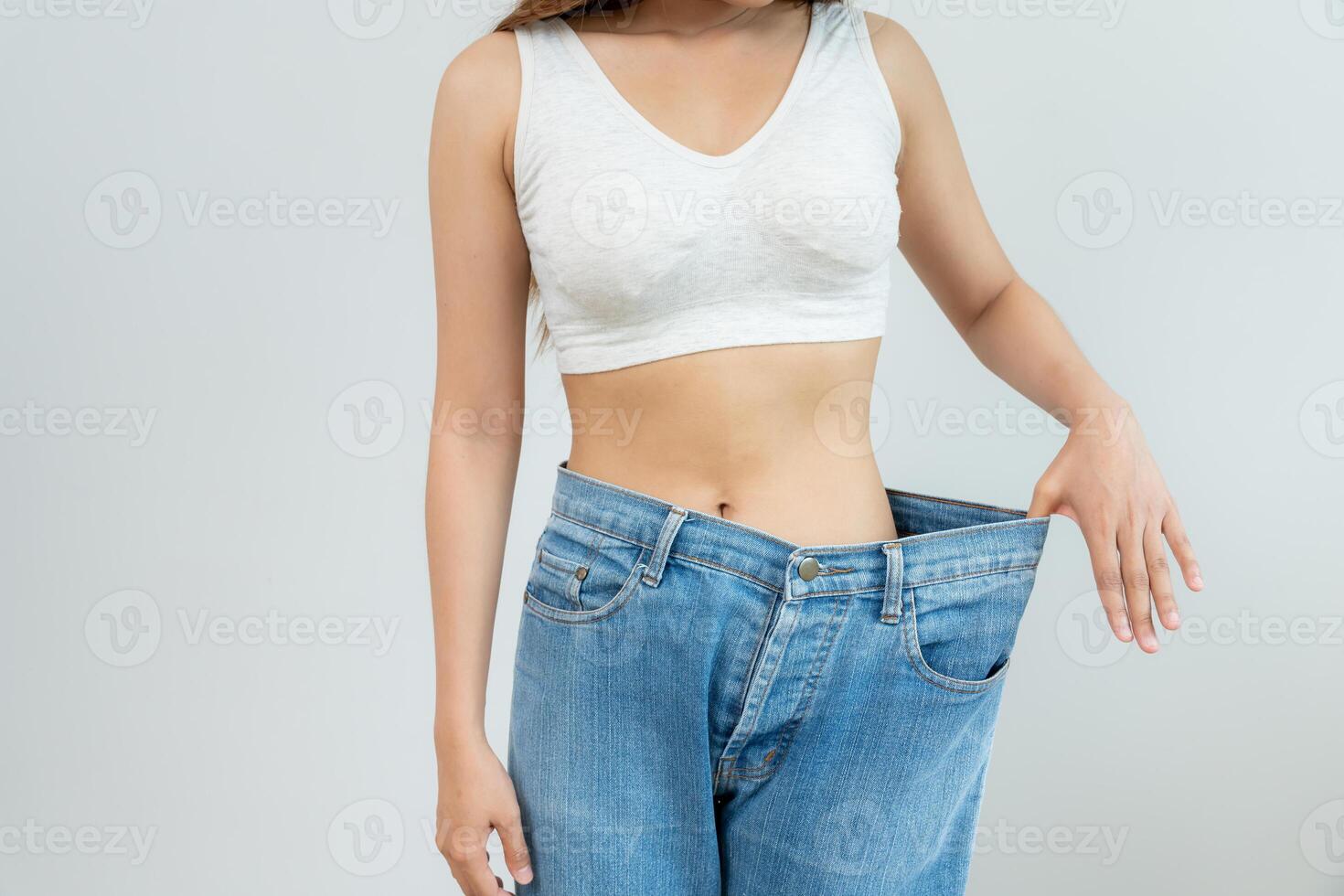 Women showing results of diet. Beautiful shape. female have a reduced waist size after under going a weight loss corse. can not wear jeans due to weight loss. balance, control, routines, exercise. photo