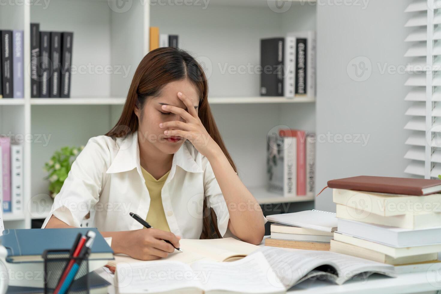 Asian student woman have anxiety because of exams, female prepare for test and learning lessons in the library. stress, despair, haste, misunderstanding reading, discouraged, expectation, knowledge photo