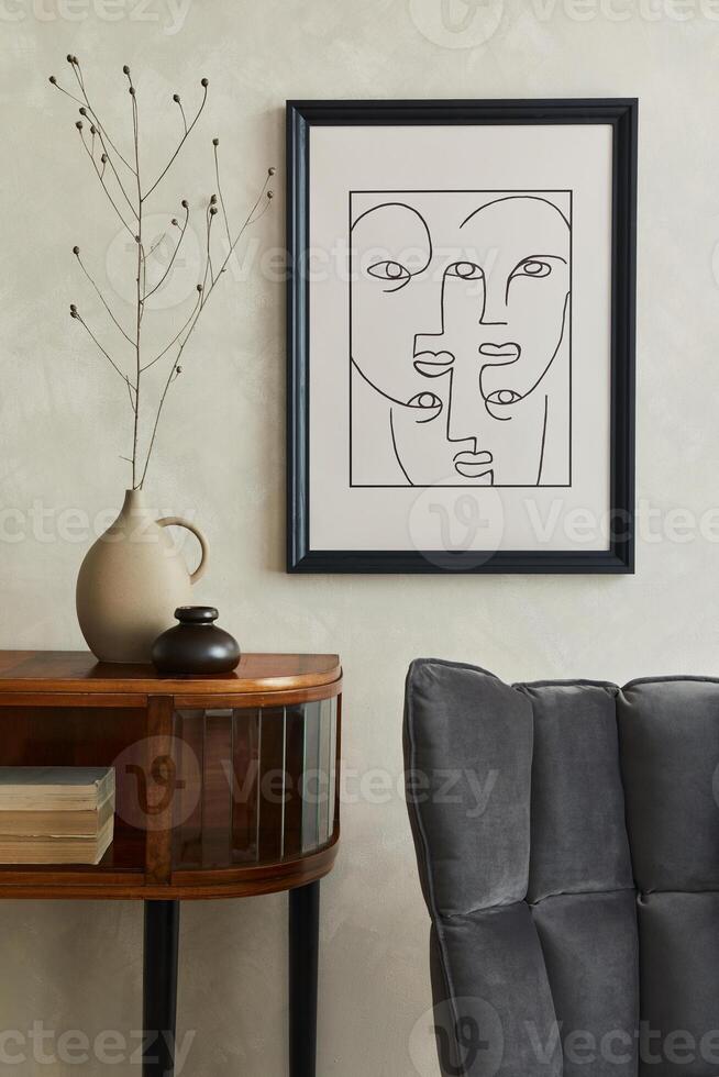 Stylish composition of creative living room interior with mock up poster frame, wooden commode, grey chair, dry banch in vase and elegant personal accessories. Neutral beige wall. Template. photo
