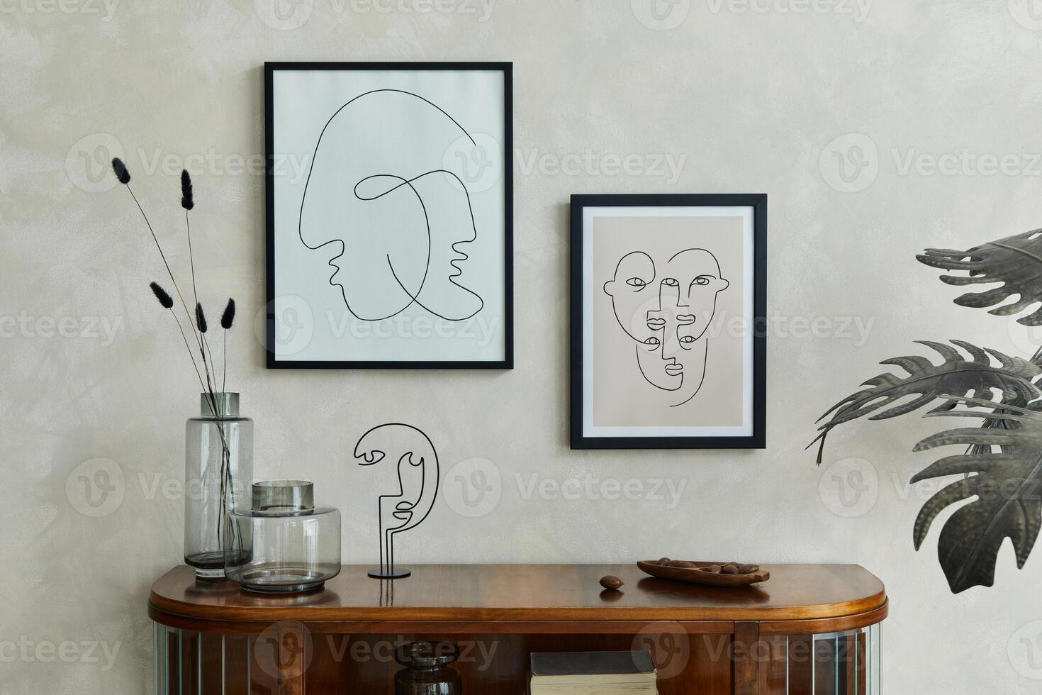 Stylish minimalistic composiotion of creative living room interior with two mock up poster frames, wooden commode, dry flowers in glass vases and elegant personal accessories. Template. photo
