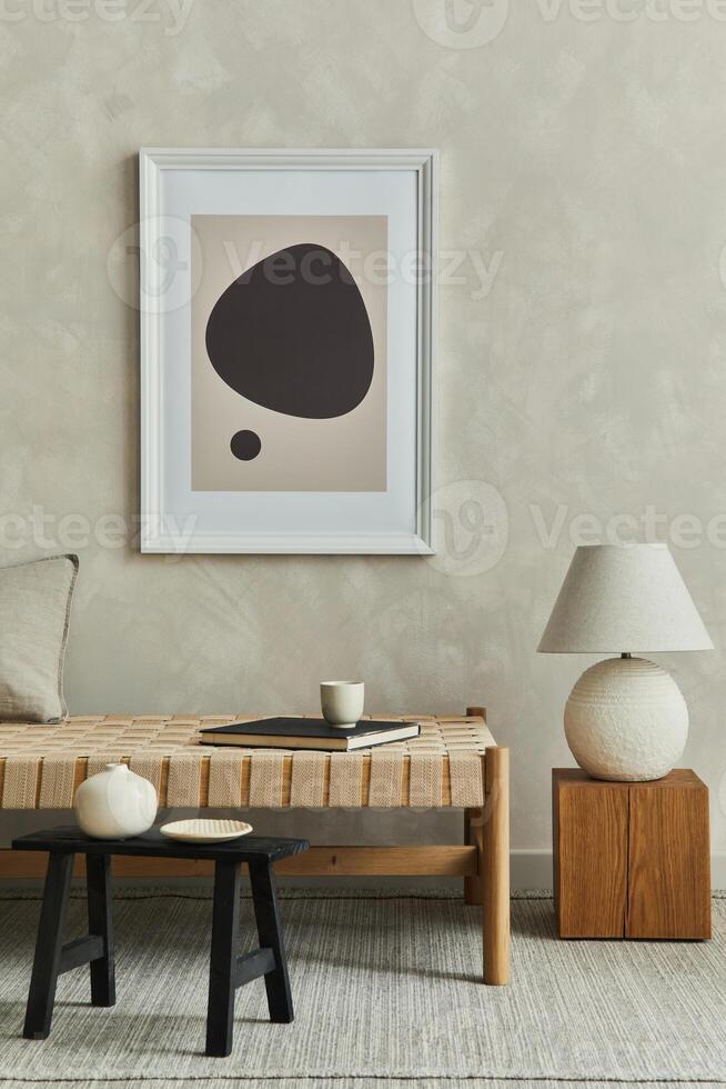 Stylish minimalistic composition of cozy living room interior with mock up poster frame, chaise longue, white lamp, wooden cube and elegant personal accessories. Neutral beige wall. Template. photo