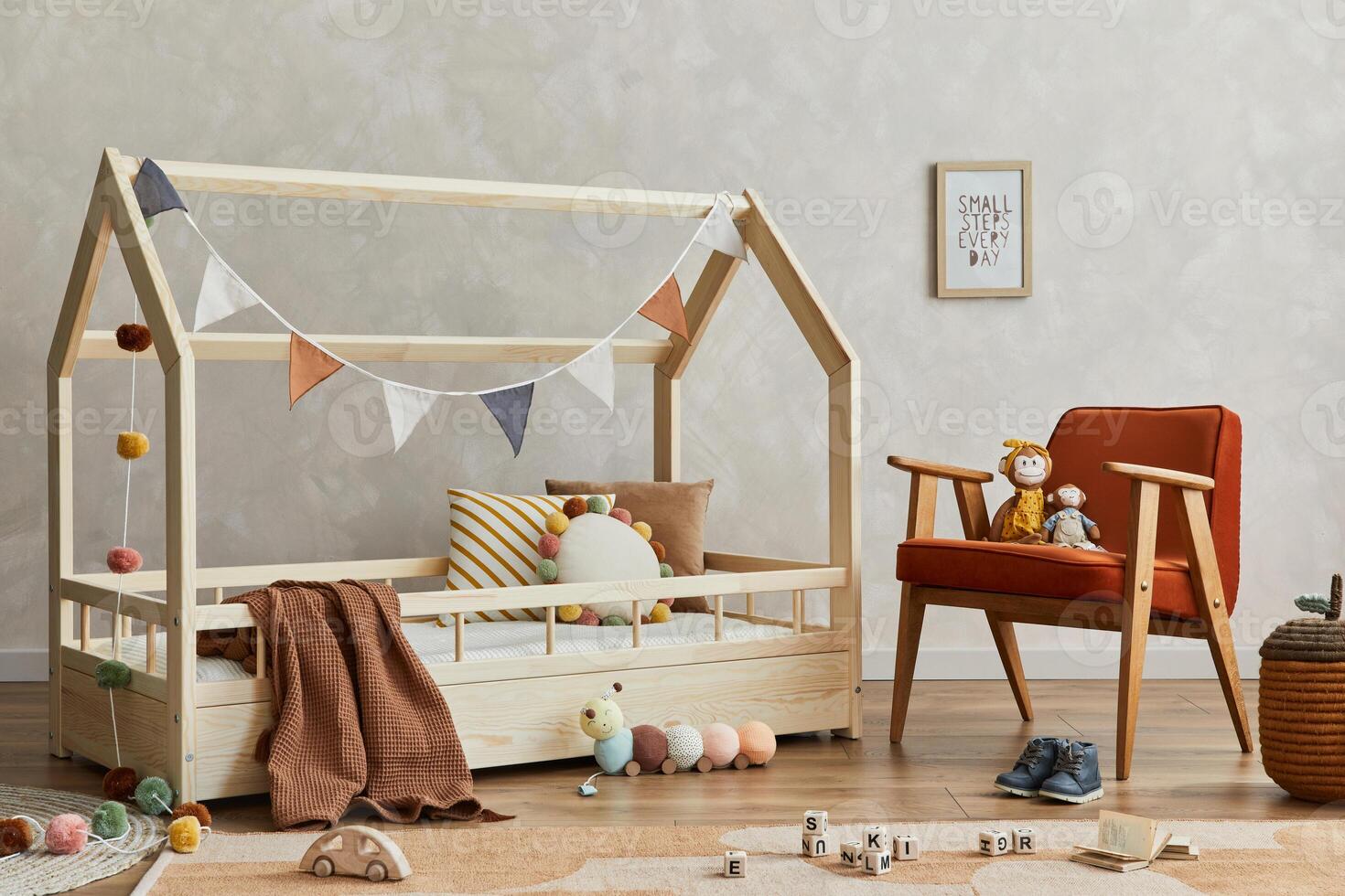 Stylish composition of cozy scandinavian child's room interior with wooden bed, armchair, plush and wooden toys and textile hanging decorations. Neutral creative wall. Template. photo