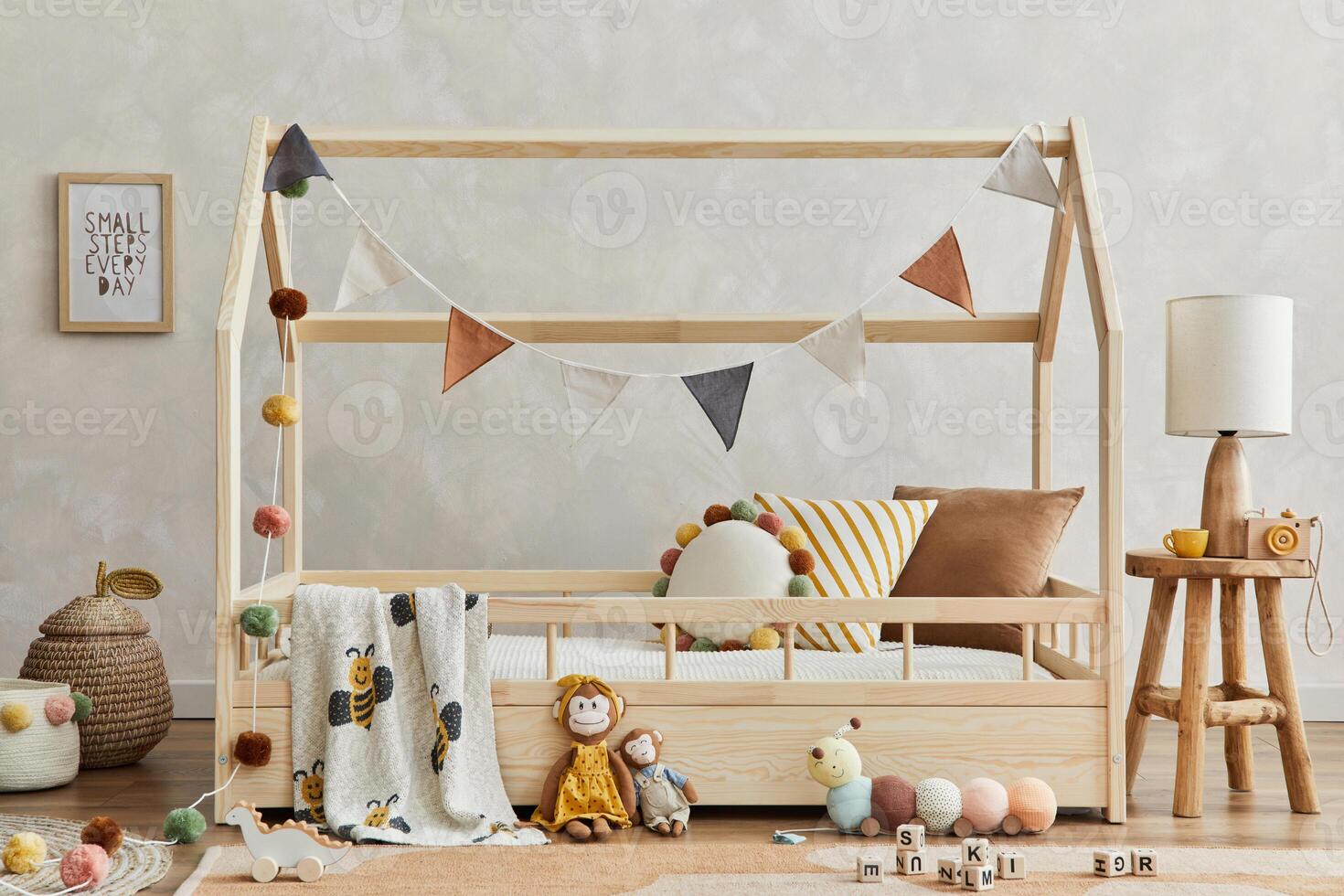 Stylish composition of cozy scandi child's room interior with wooden bed, pillows, elegant lamp, plush and wooden toys and textile hanging decorations. Creative wall, carpet on the floor. Template. photo