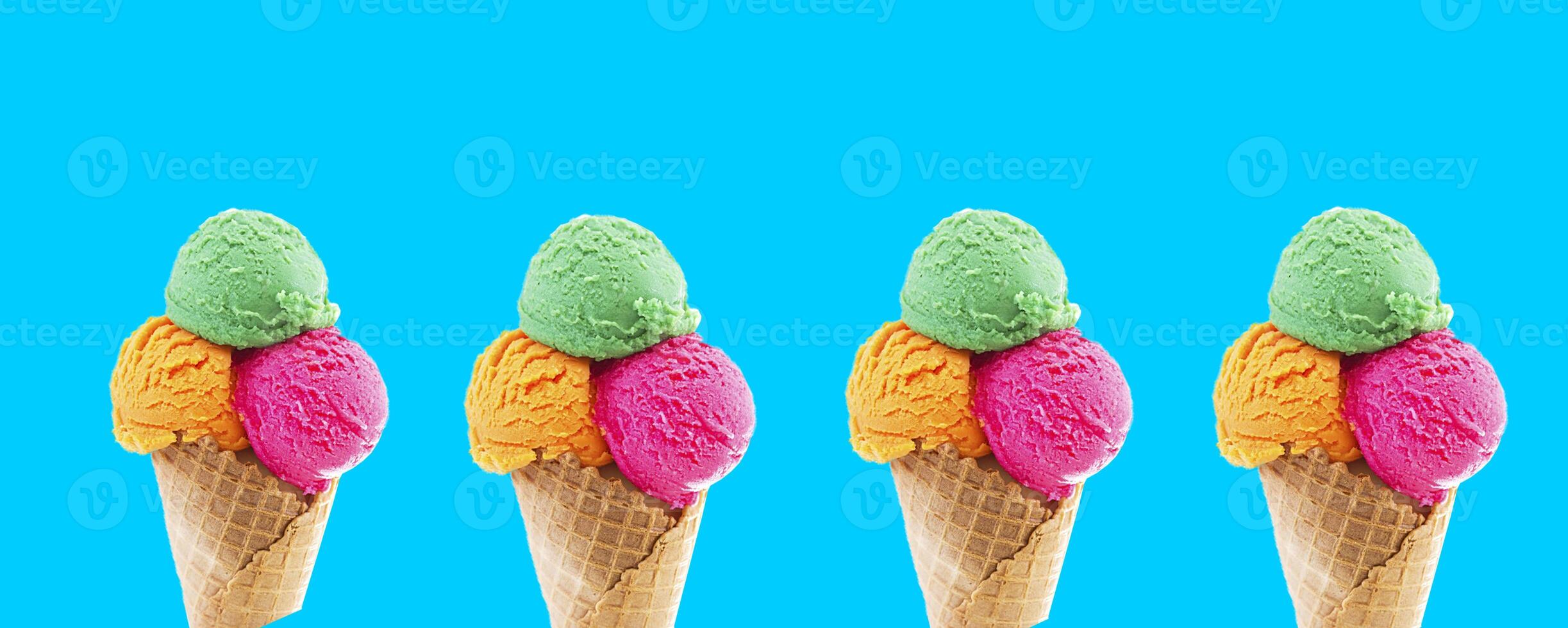 Mixed ice cream scoops in cone on blue background. photo