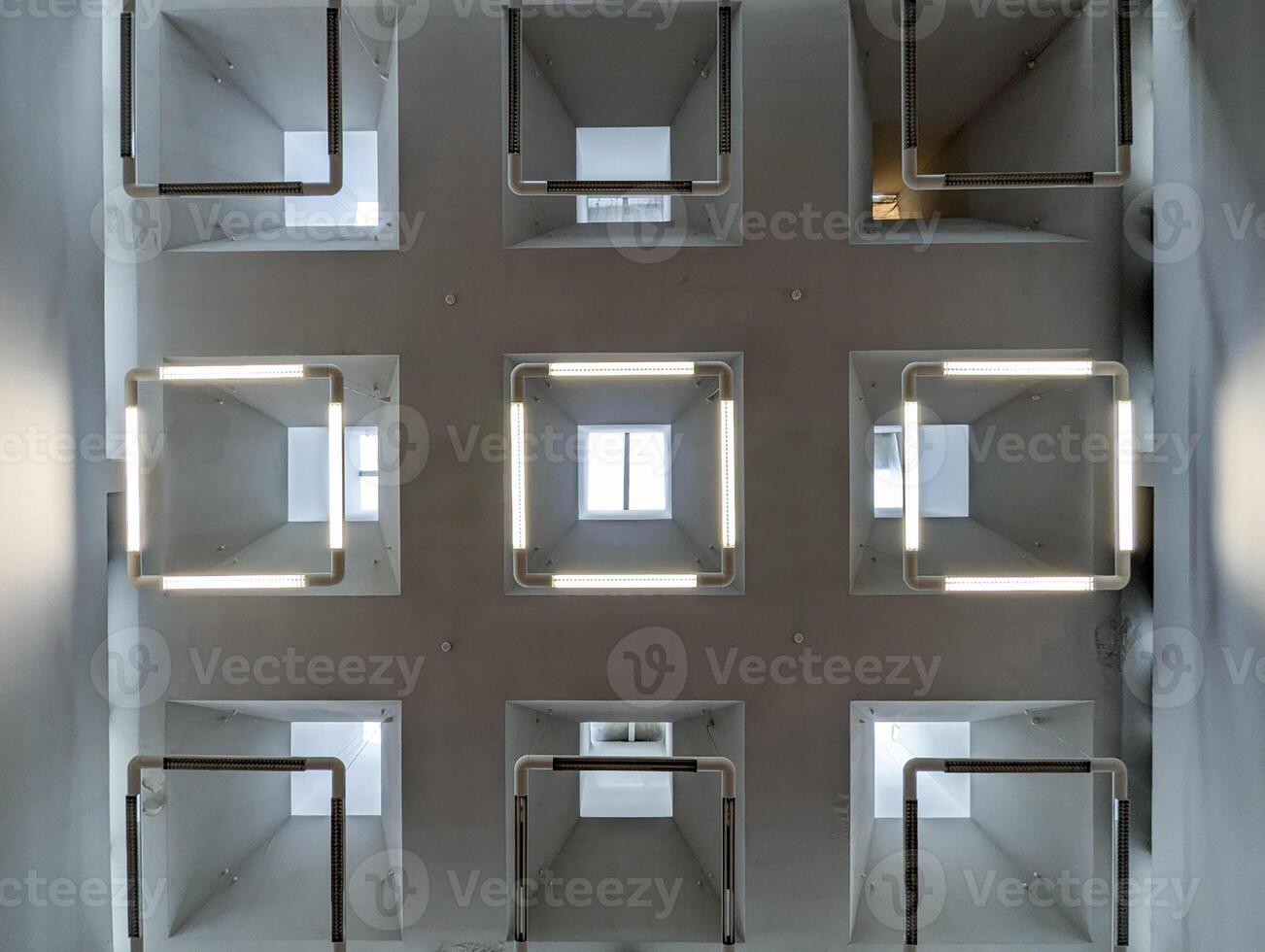 grid on the ceiling made of nine square structures, each square frame containing a window photo