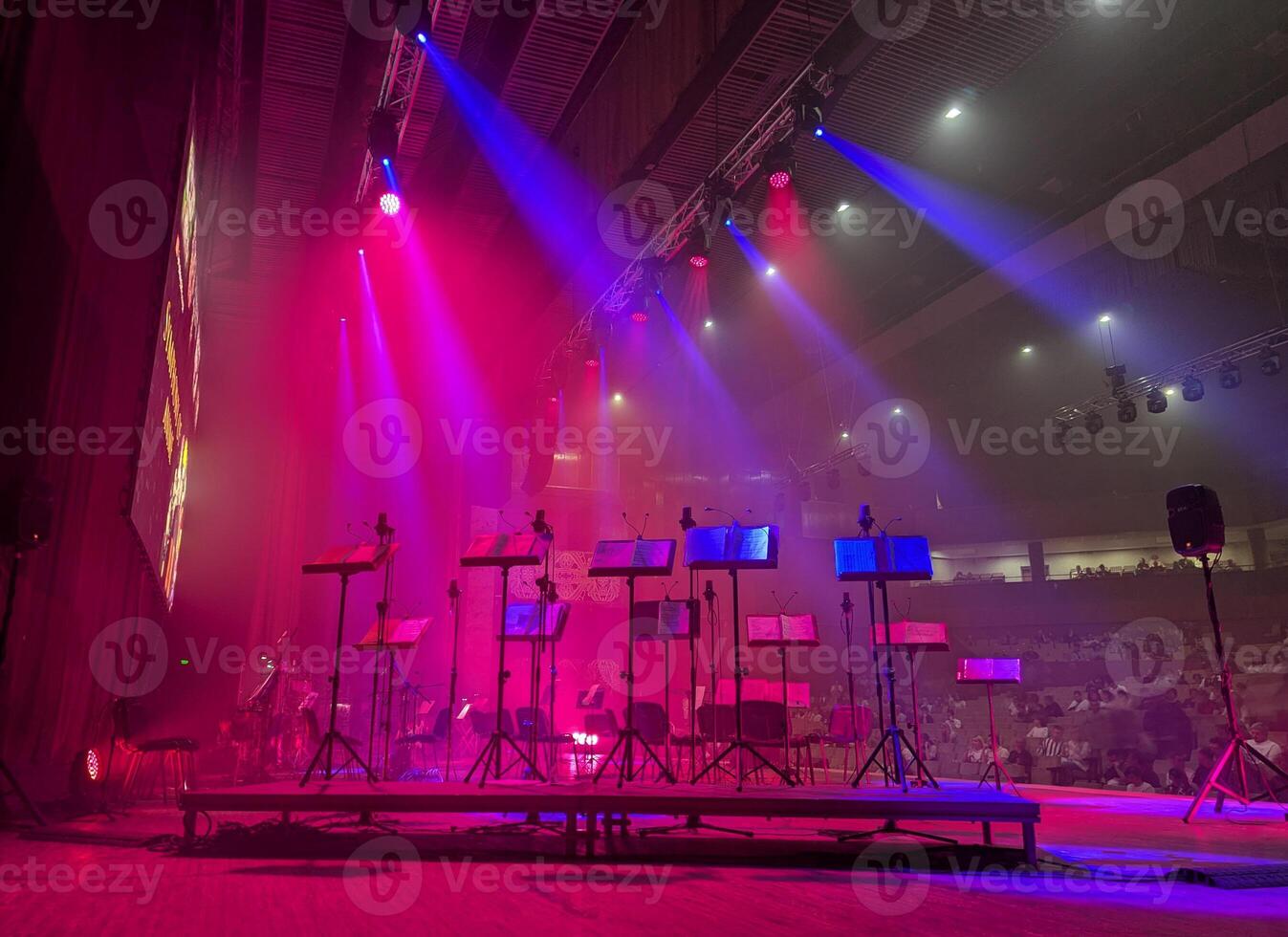 stage with music stands and musical equipment illuminated by beams of stage light photo