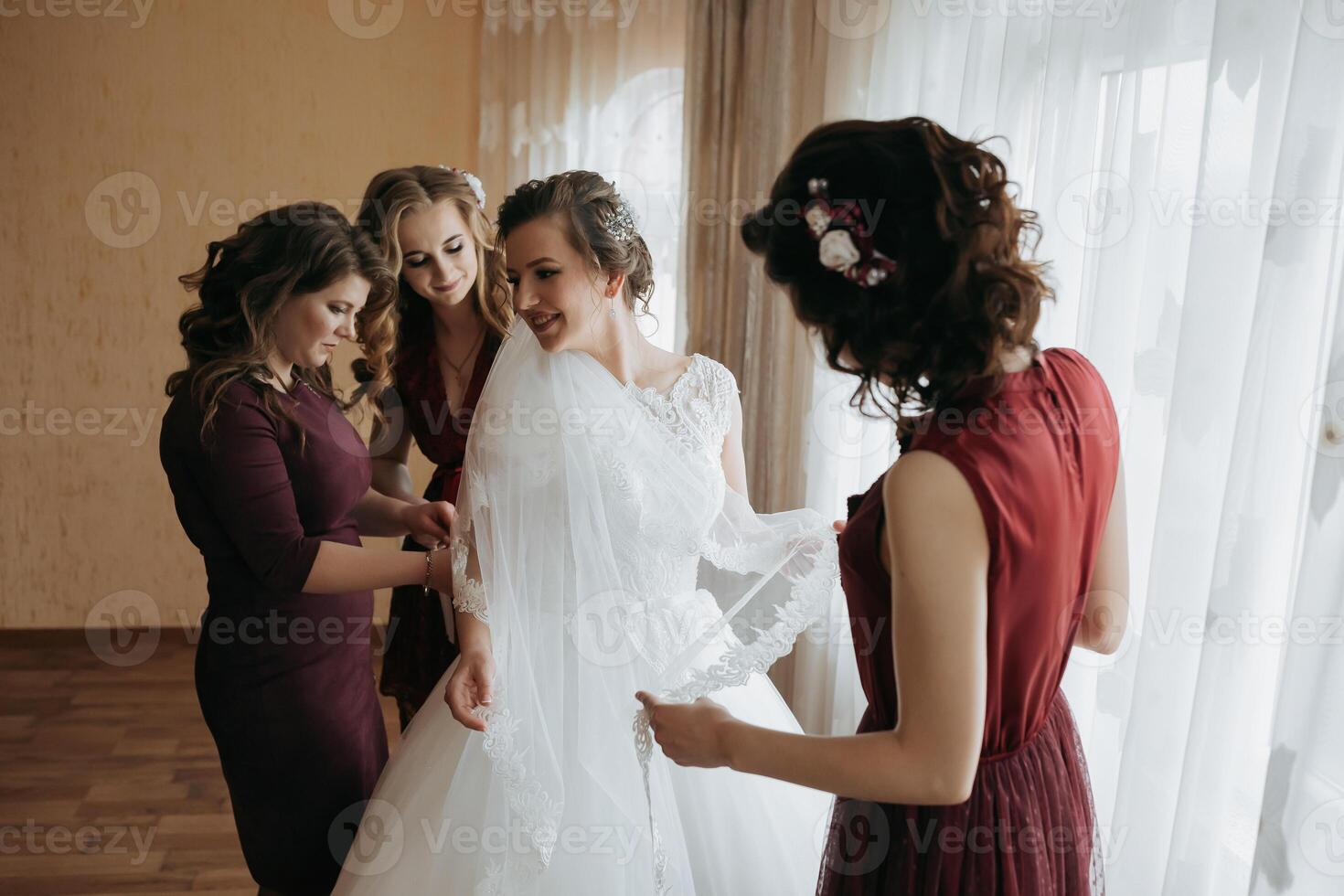 A bride is getting ready for her wedding with her bridesmaids photo