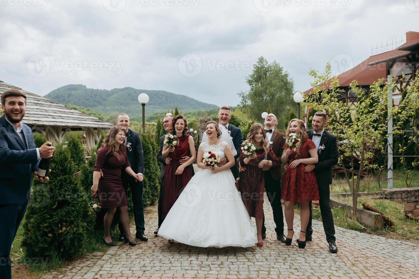 A group of people are posing for a picture, including a bride and groom photo