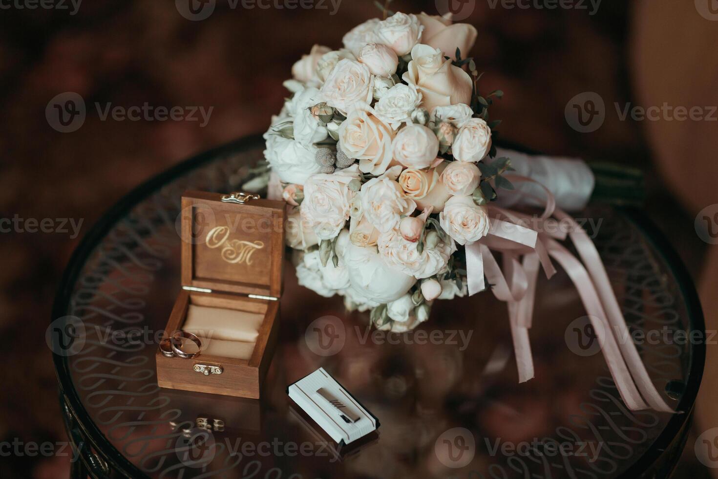 A bouquet of flowers sits on a table next to a wooden box with the letters O photo