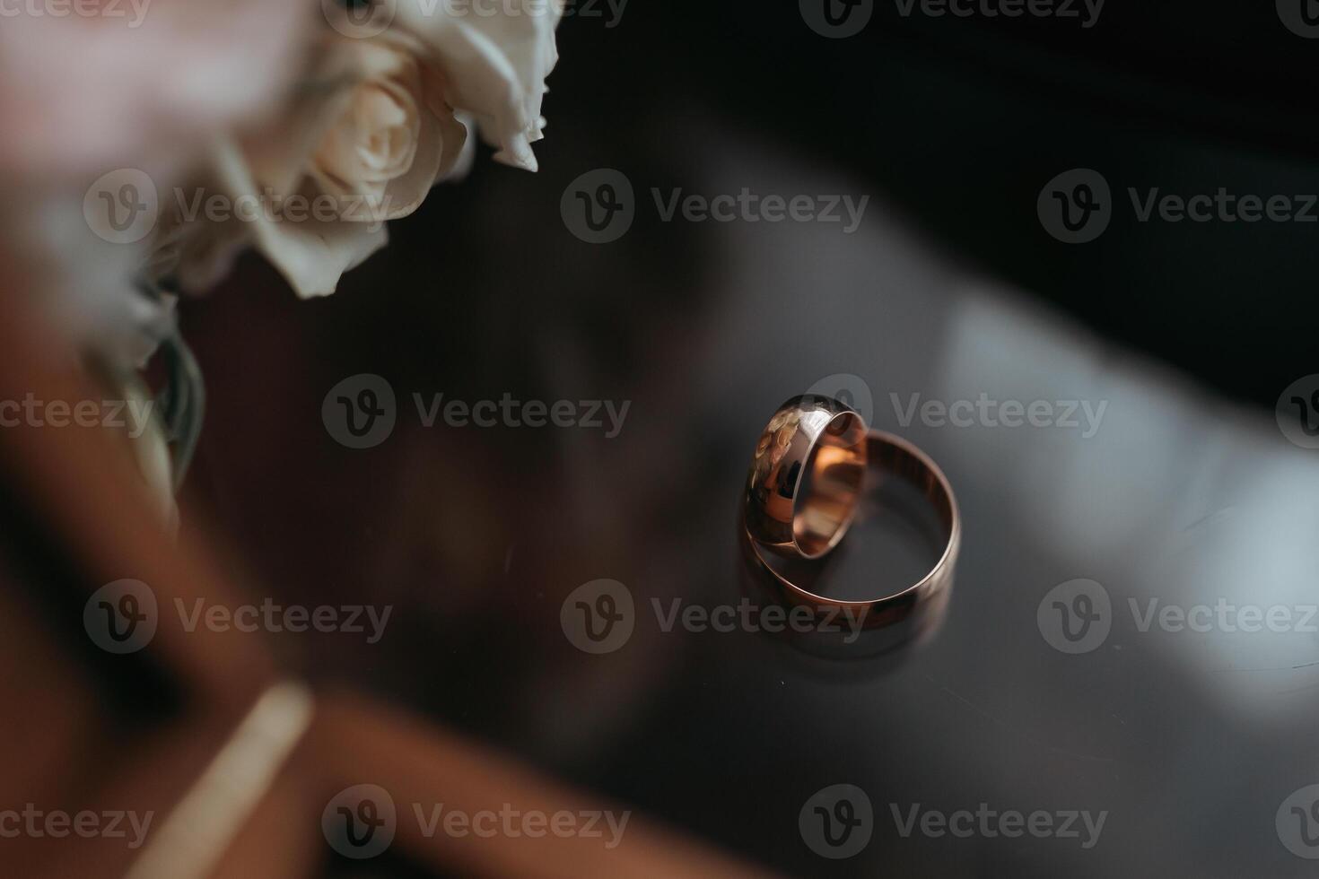 Two gold wedding rings are on a table photo