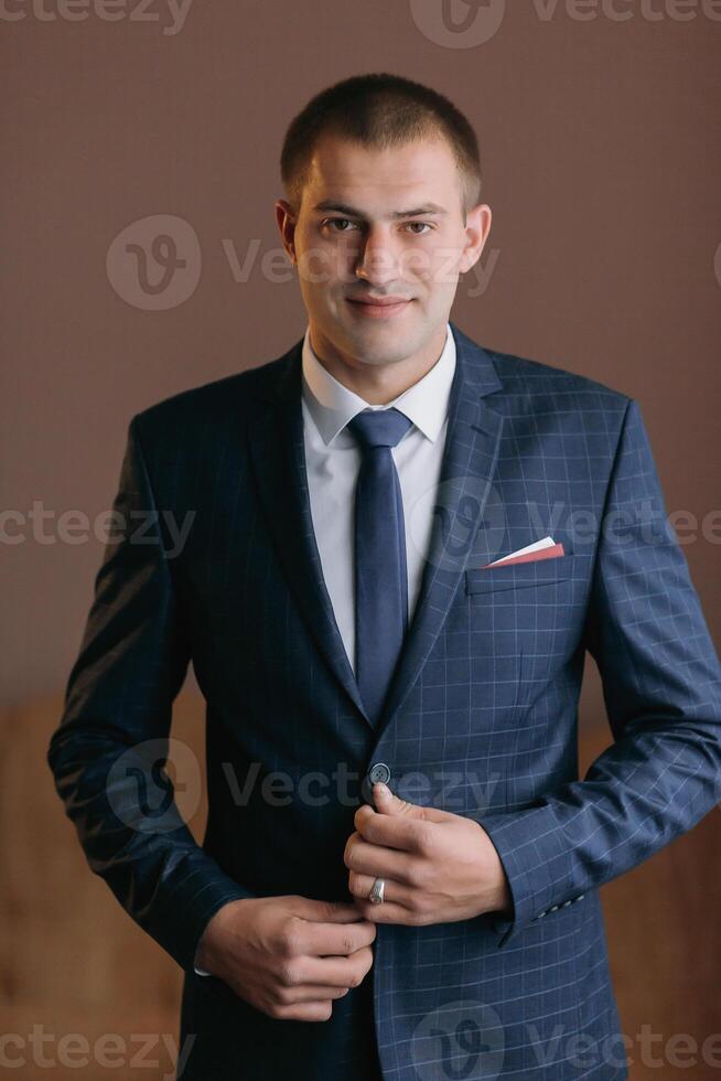 A man in a suit and tie is smiling and holding his jacket open photo