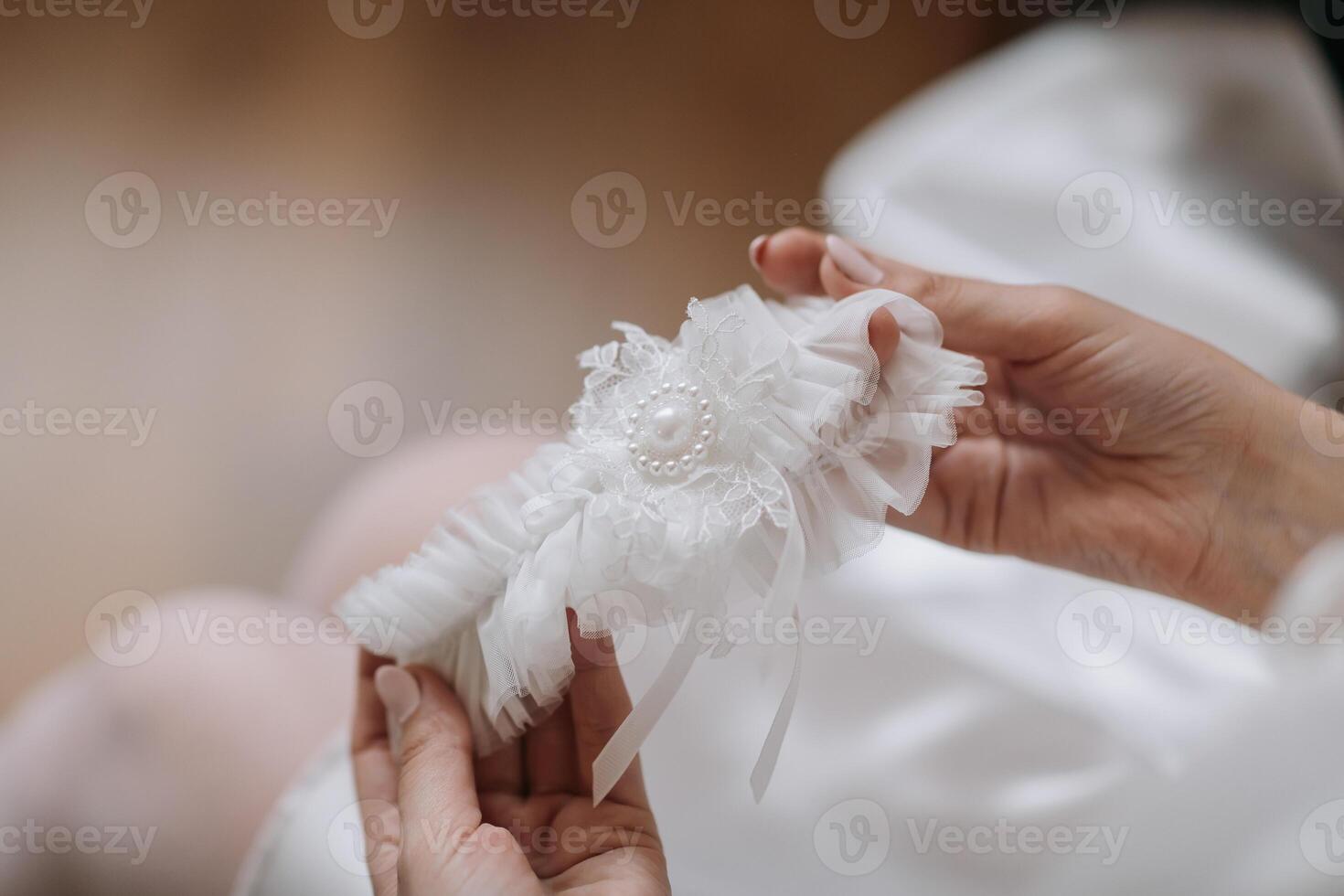 A woman is holding a white wedding band with a pearl on it photo