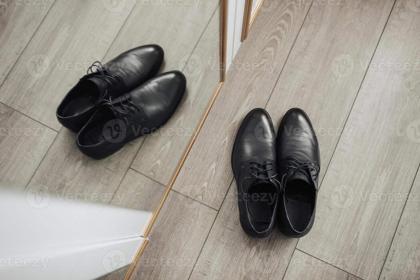 Two black shoes are standing in front of a mirror photo