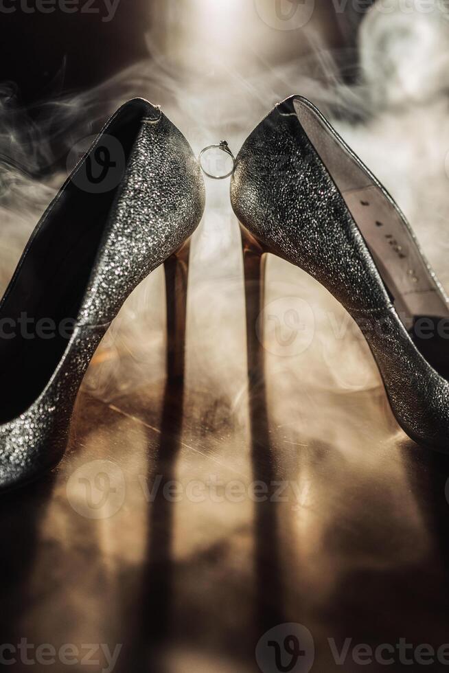 Two silver high heels with a ring on the left one photo