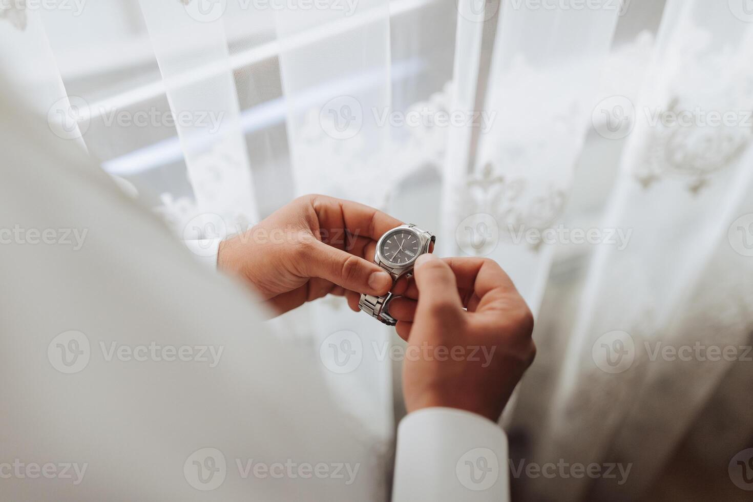 A man is holding a watch in his hand photo