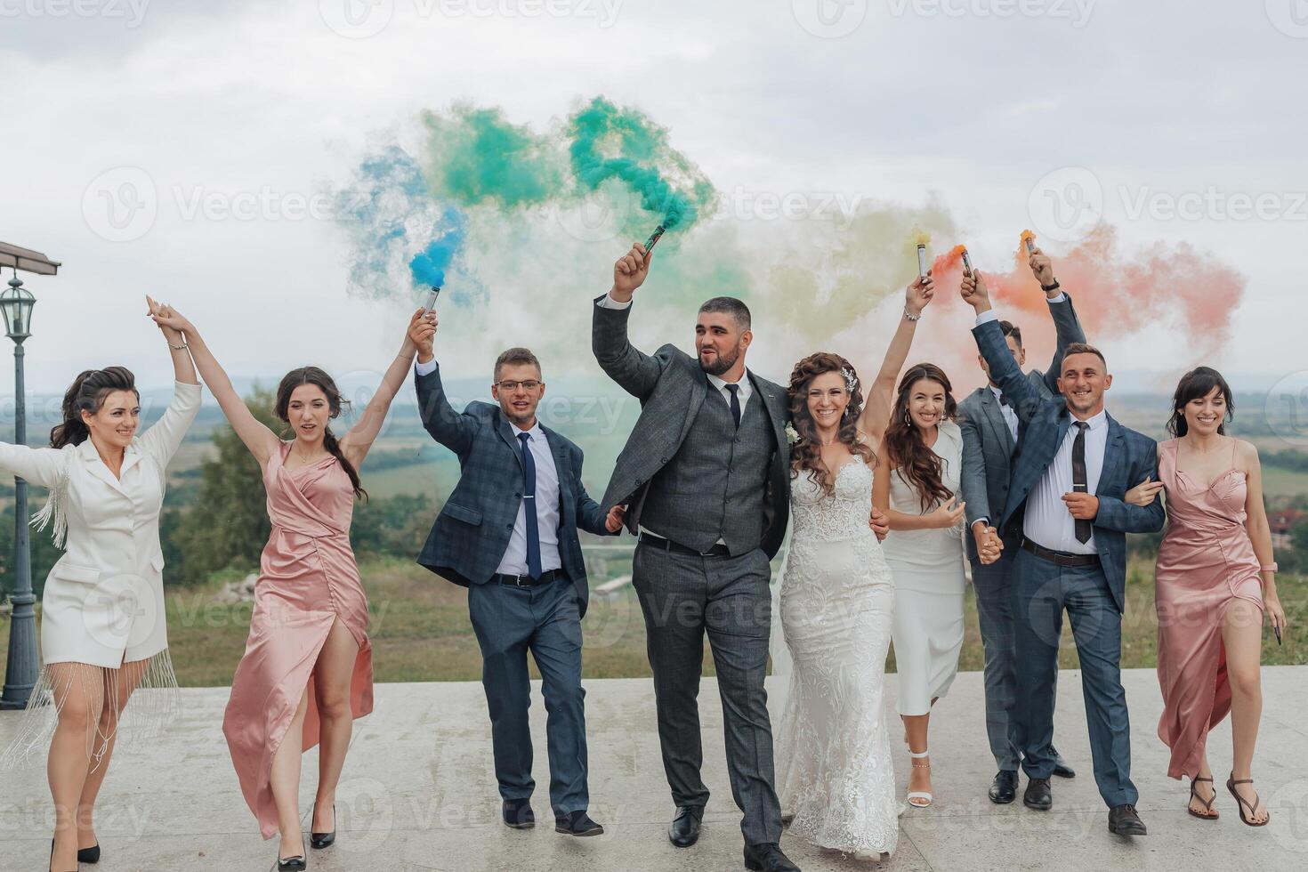 A group of people are posing for a photo, with some of them holding smoke bombs photo