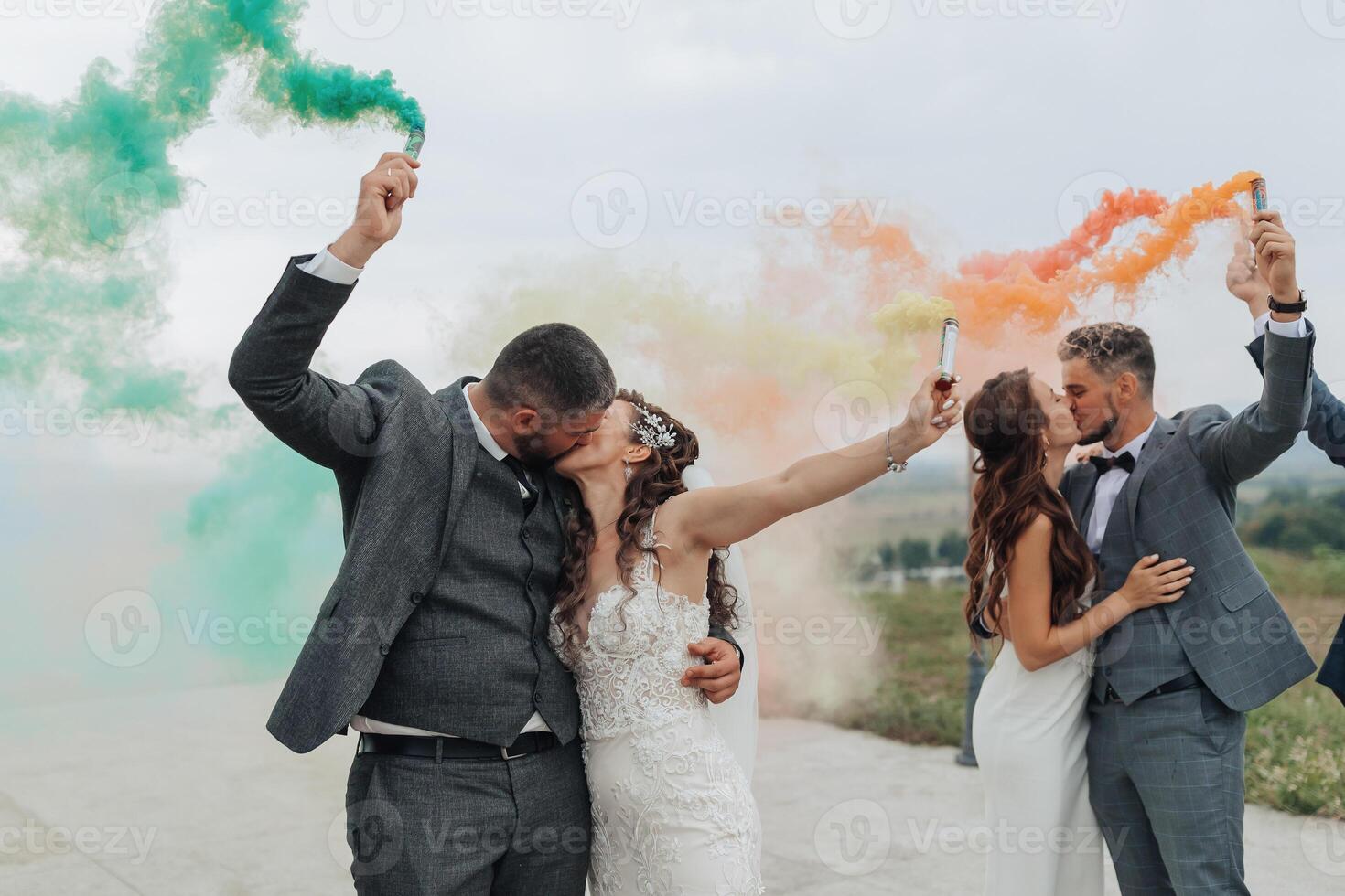A couple is kissing in front of a green, yellow, and red smoke trail photo