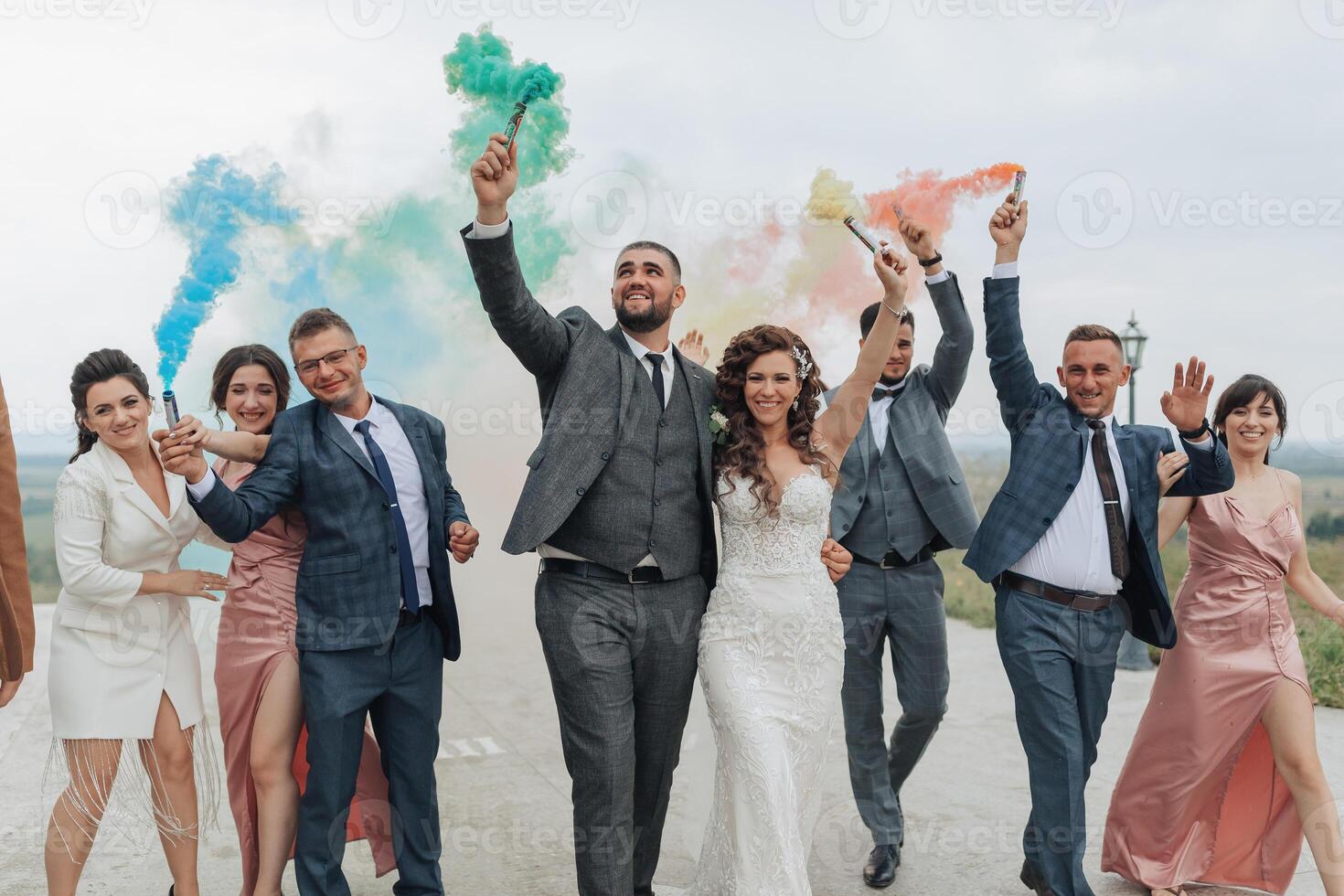 A group of people are walking down a road, some of them holding smoke bombs photo