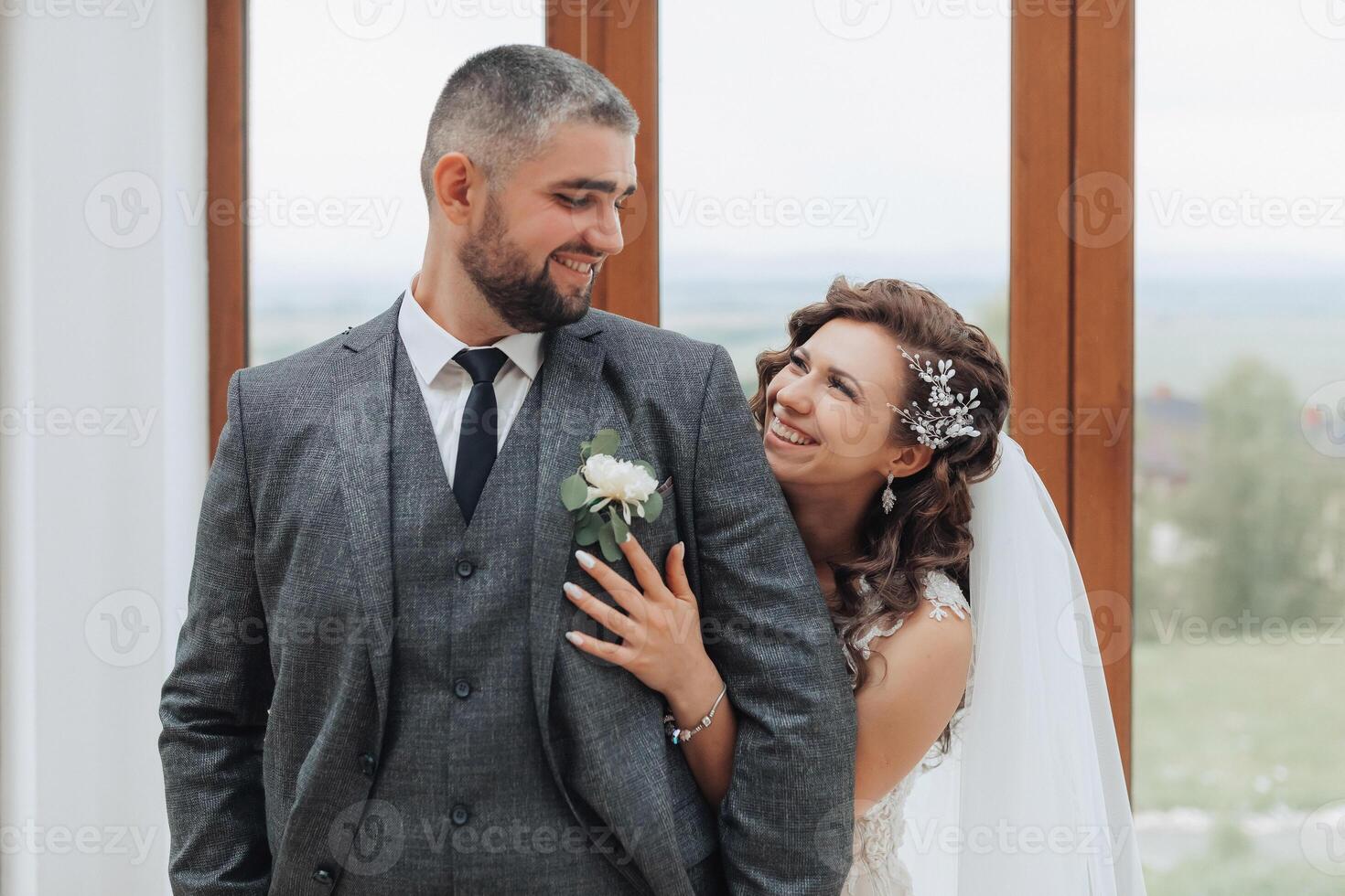A man and woman are smiling at the camera, with the man wearing a suit and tie photo