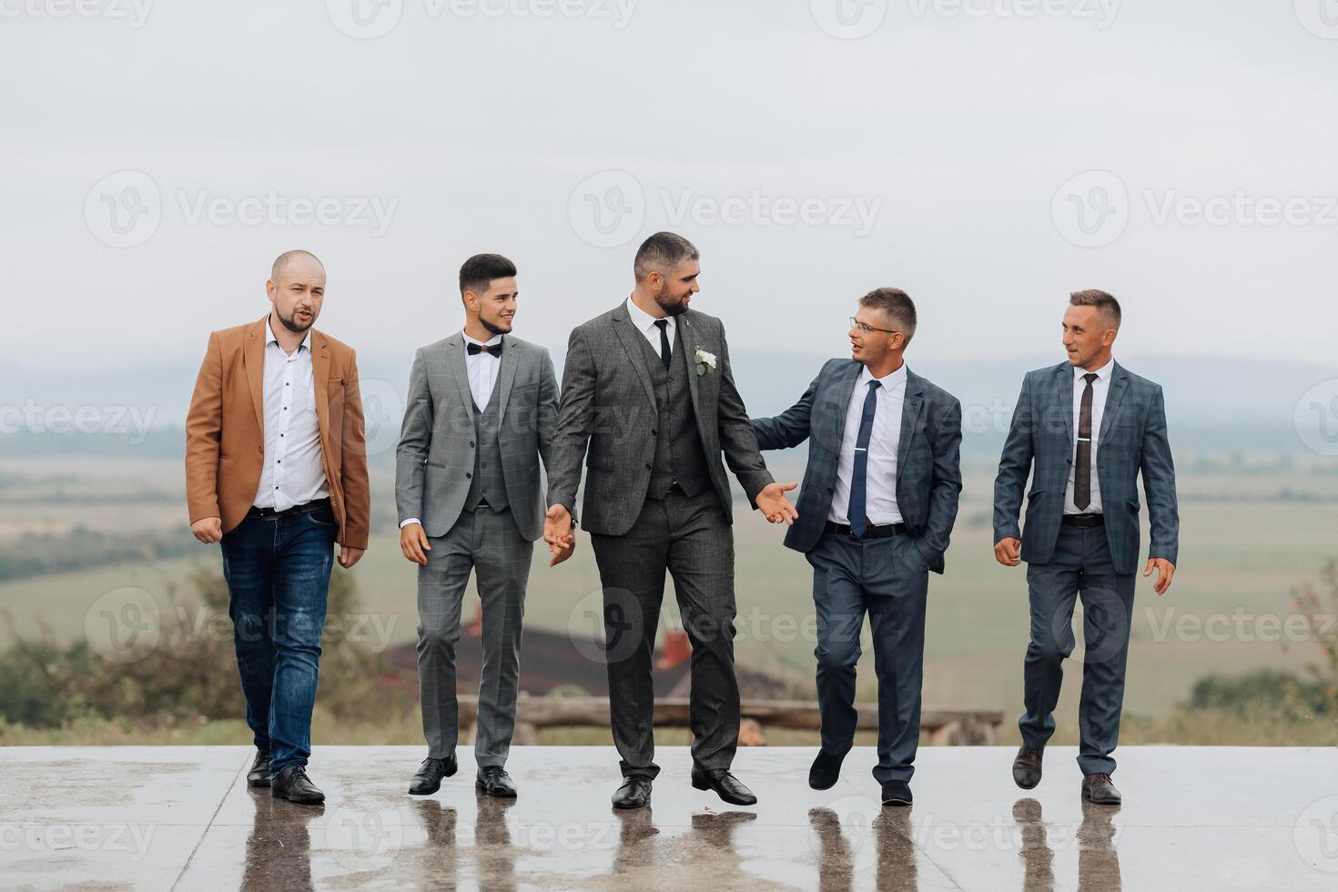 A group of five men are dressed in suits and ties photo