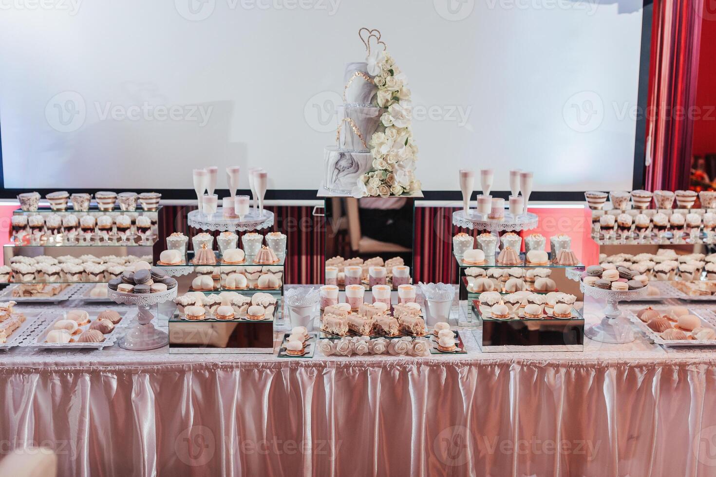 A table with a white tablecloth and a cake with a heart on top photo