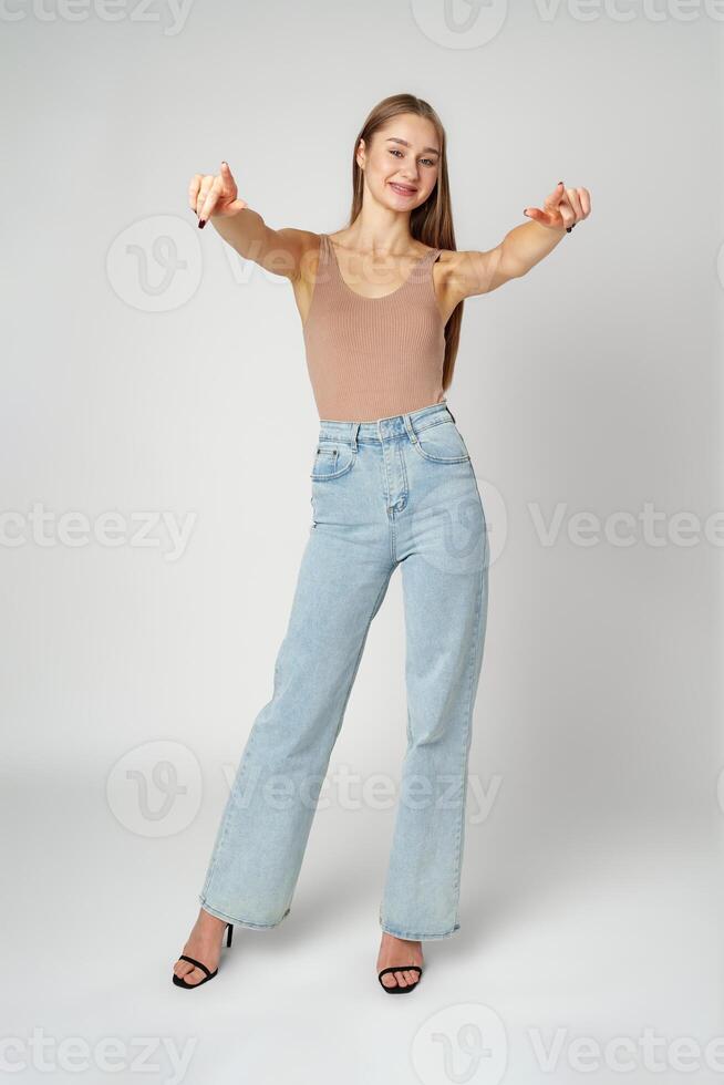 Young Woman Pointing Towards Camera With a Playful Expression in a Studio photo