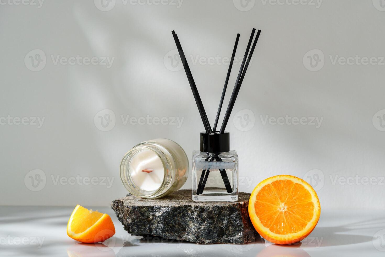 Elegant Aroma Diffuser With Black Reeds on a Slate Base Next to a Fresh Orange Slice photo
