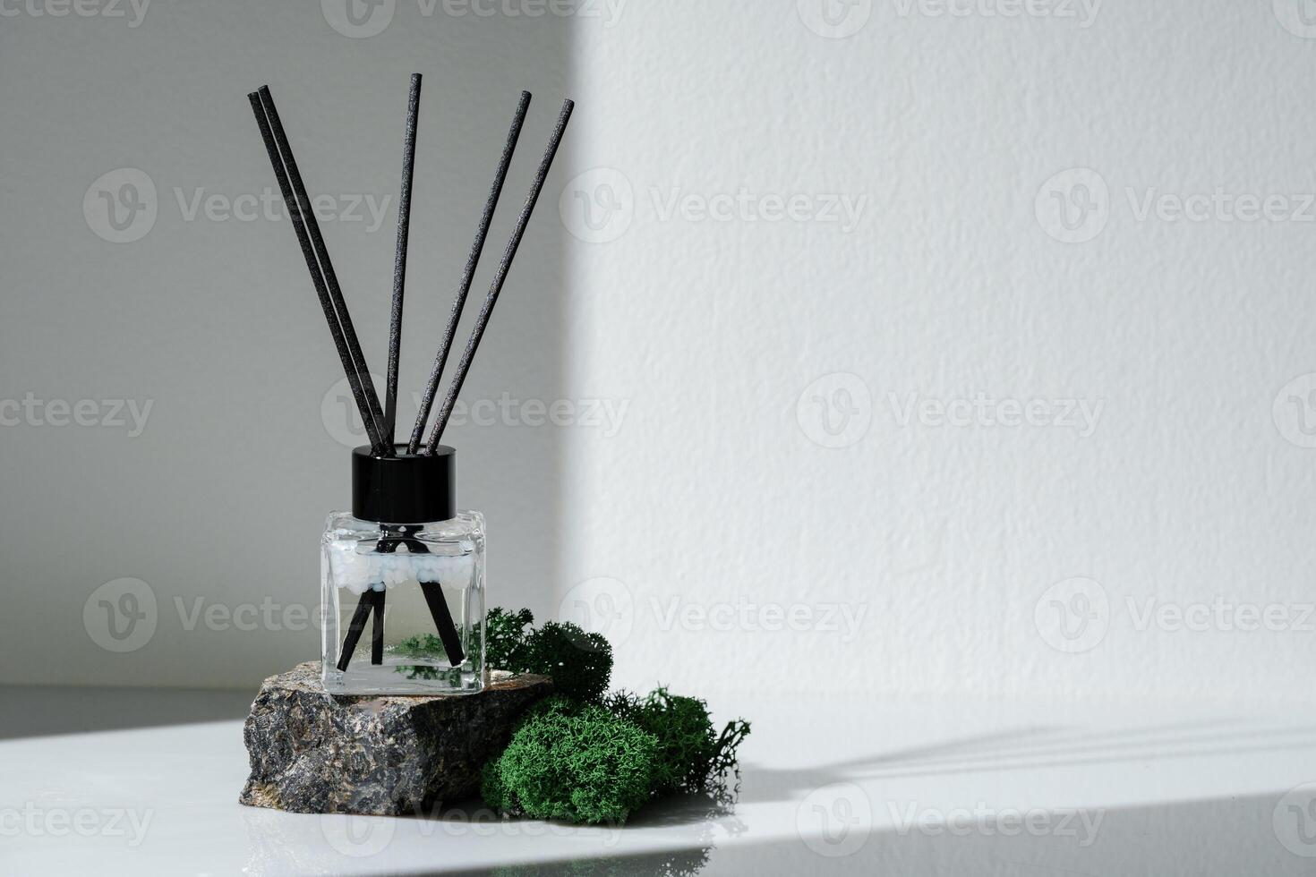 Elegant Aroma Diffuser With Black Reeds on a Granite Base Next to Moss Decor photo