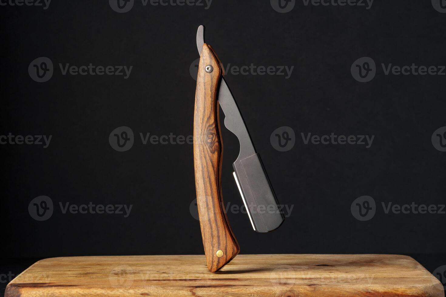 Handcrafted Wooden Folding Knife Displayed on a Rustic Table Against a Dark Background photo