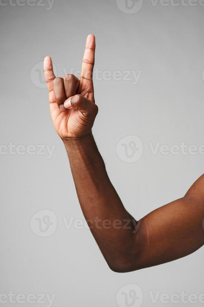 Hand Making the Rock N Roll Sign Against a Plain Gray Background photo