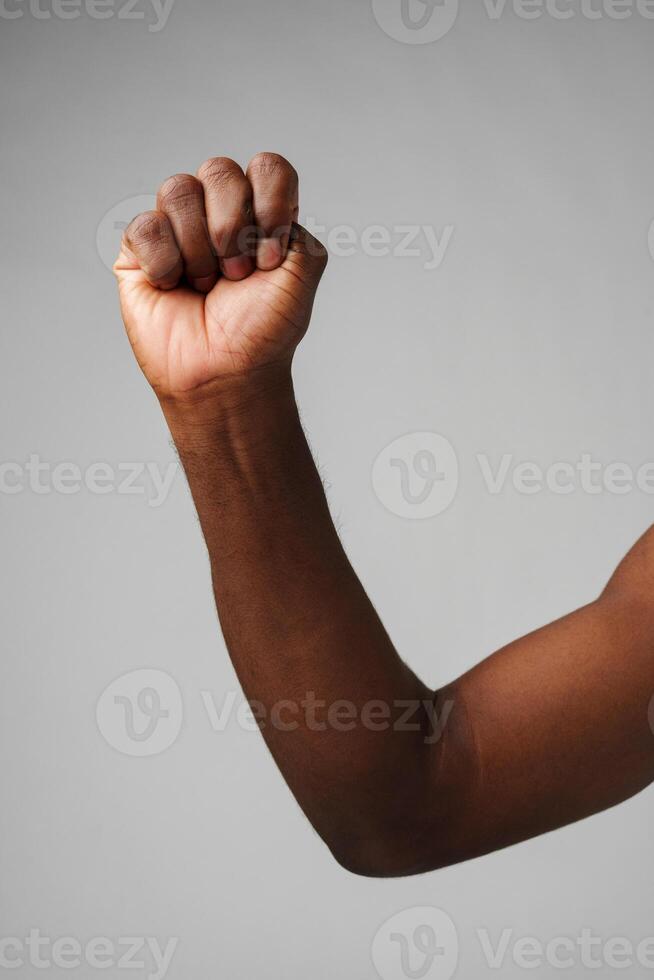 Raised Fist of Determination and Strength Against a Gray Background photo