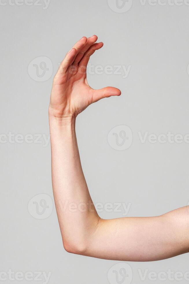 Outstretched Bare Human Arm Against a Plain Gray Background photo