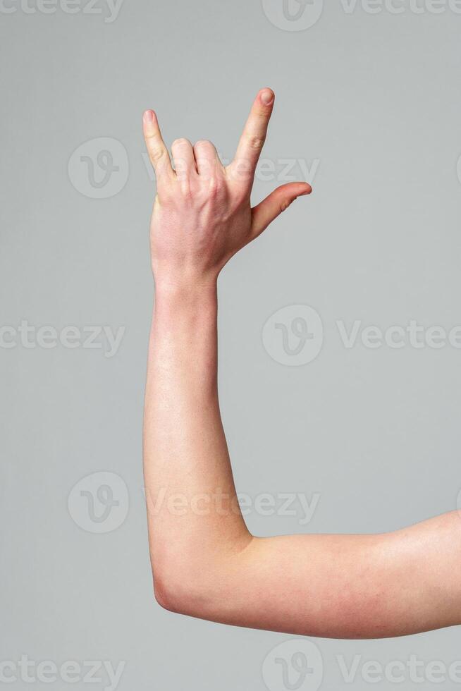 Hand Gesturing the Rock and Roll Sign Against a Neutral Background photo