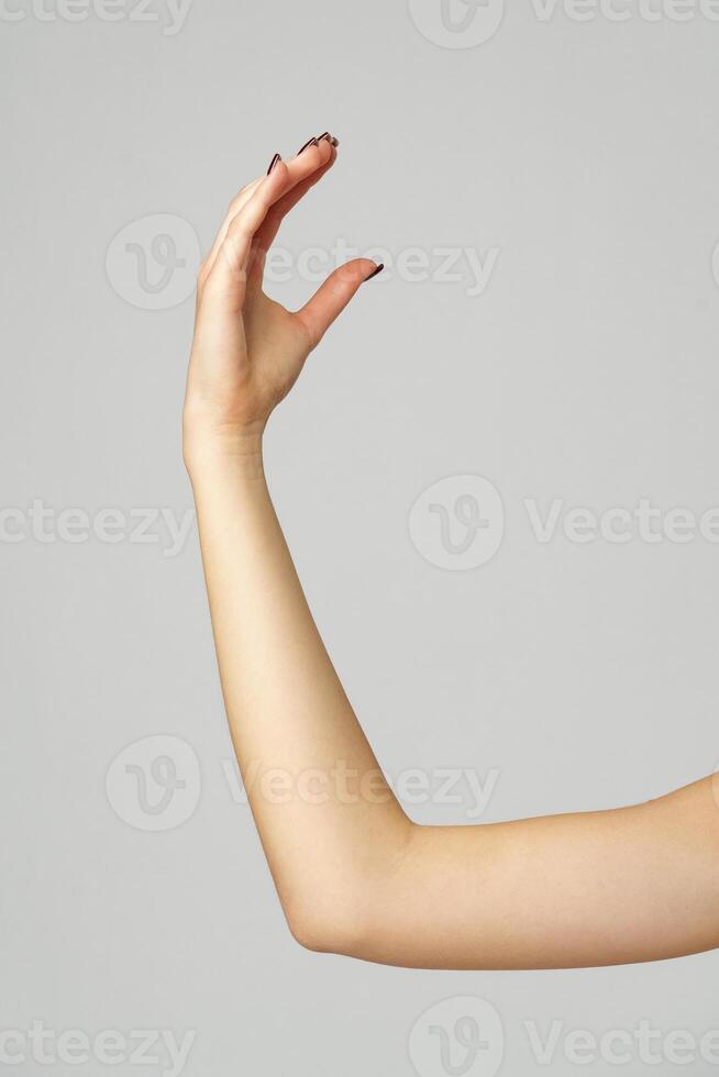 Young woman hand gesture on gray background photo