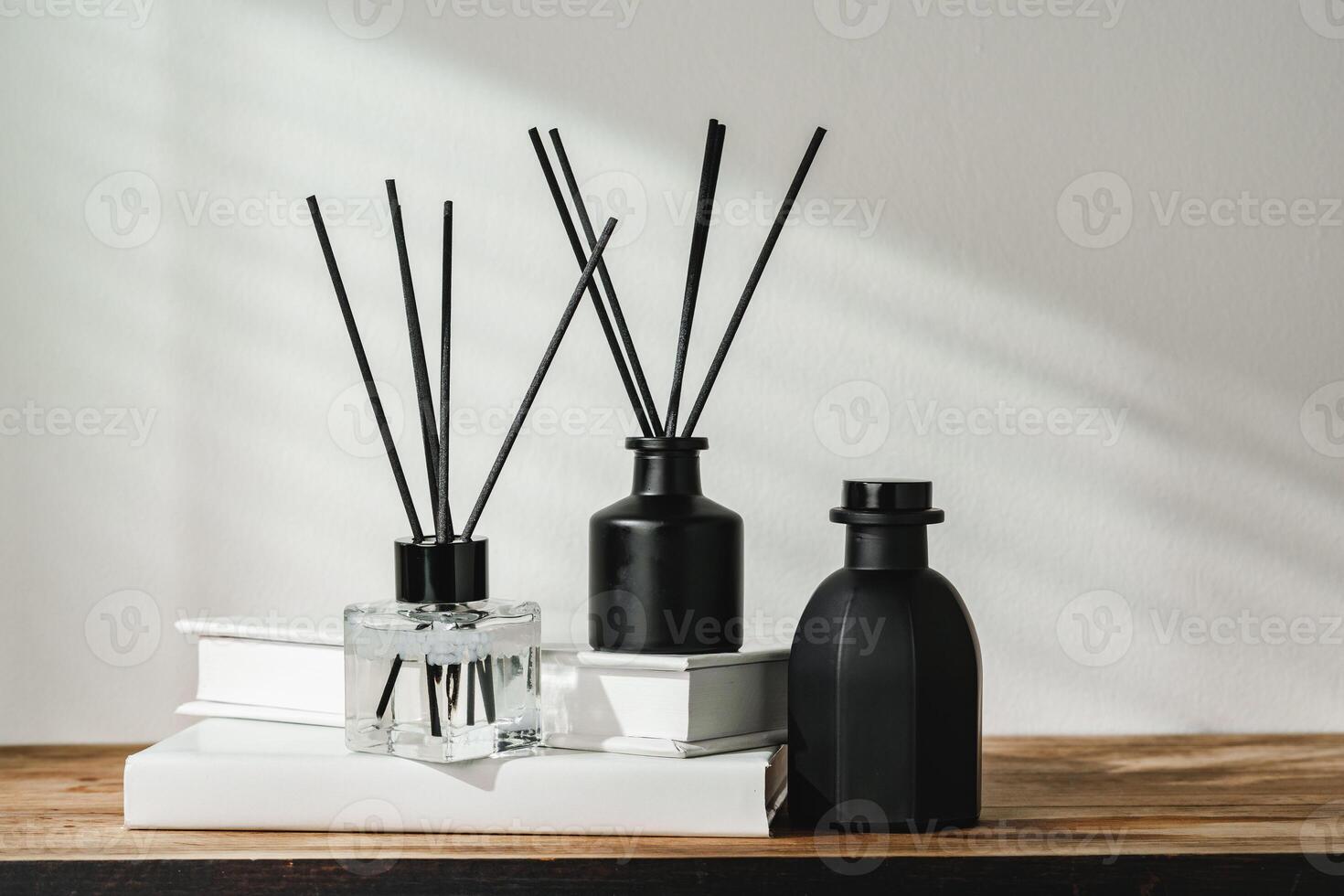 Aromatic Reed Diffuser on White Books With Shadows Playing on the Wall photo
