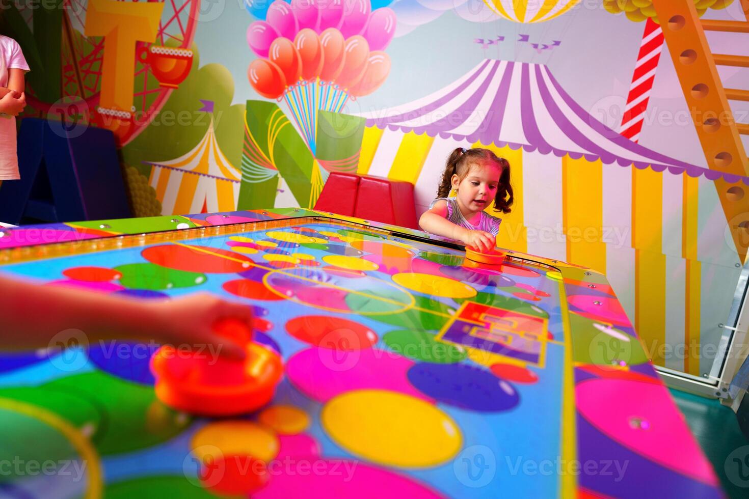 Young Girl Engaging in Colorful Board Game Fun at a Vibrant Playroom photo