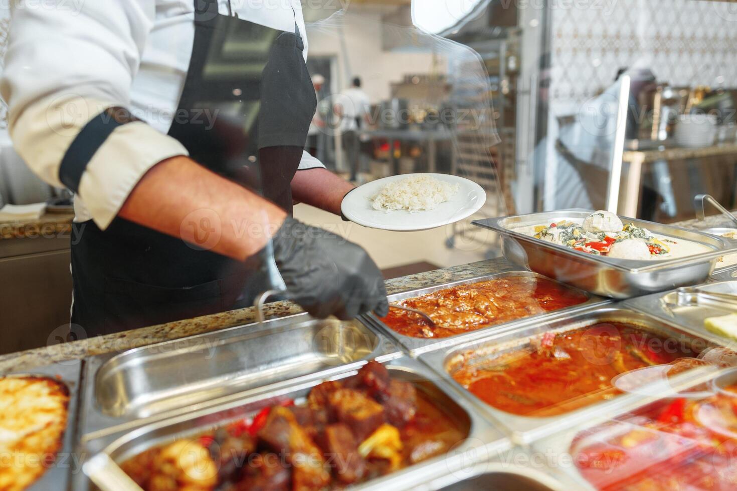 Chef Serving Freshly Cooked Dishes at a Restaurant Buffet During Lunchtime photo