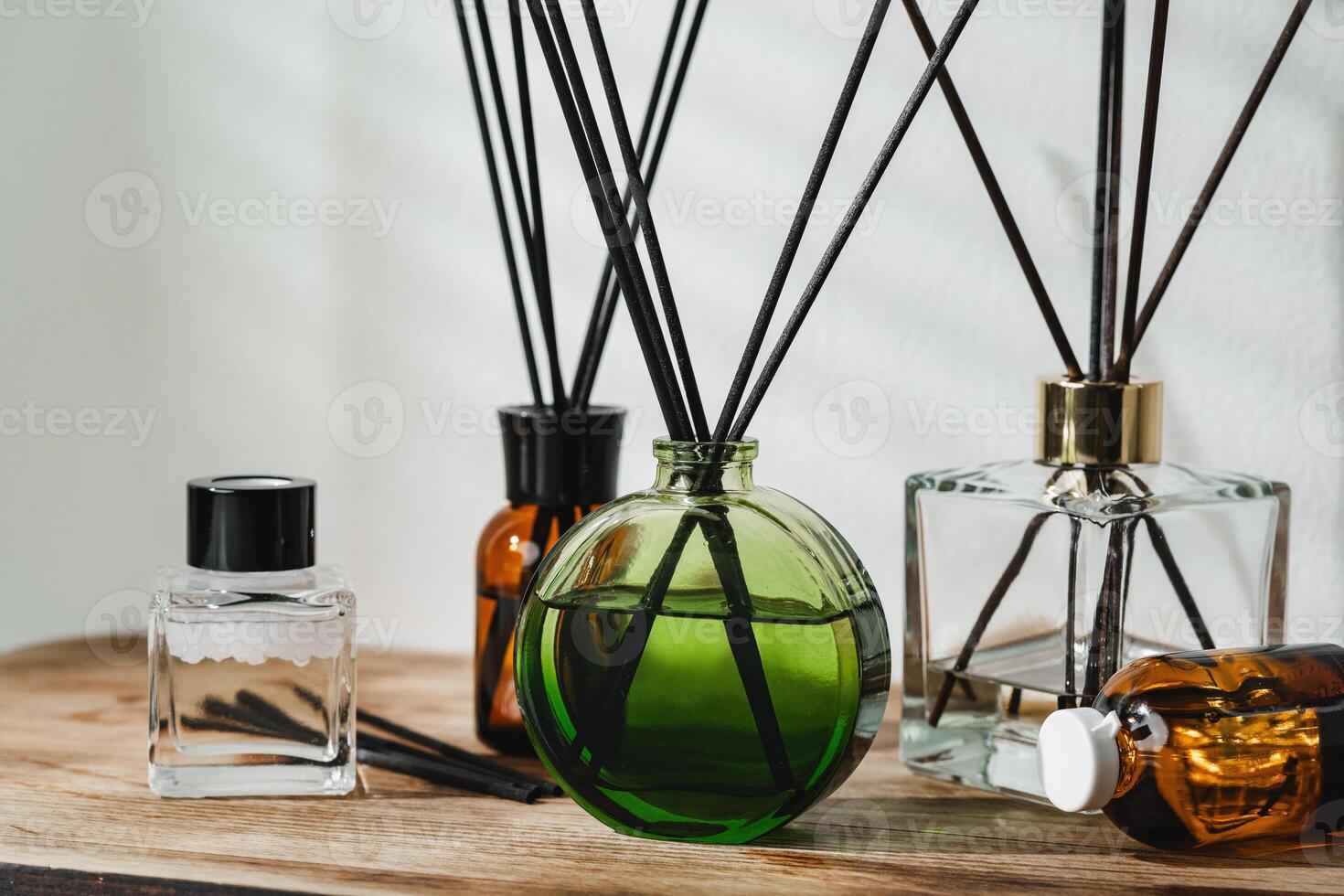 A Collection of Aromatic Reed Diffusers on a Wooden Table Against a Neutral Background photo