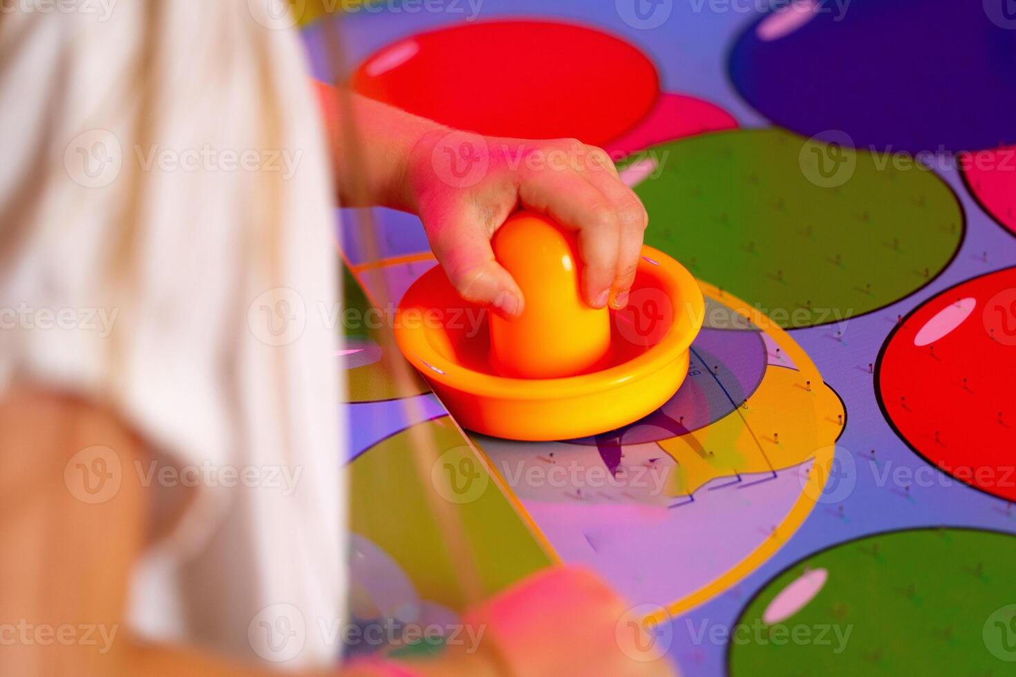 Young Child Playing Twister Game With Colorful Spinner on Bright Mat photo